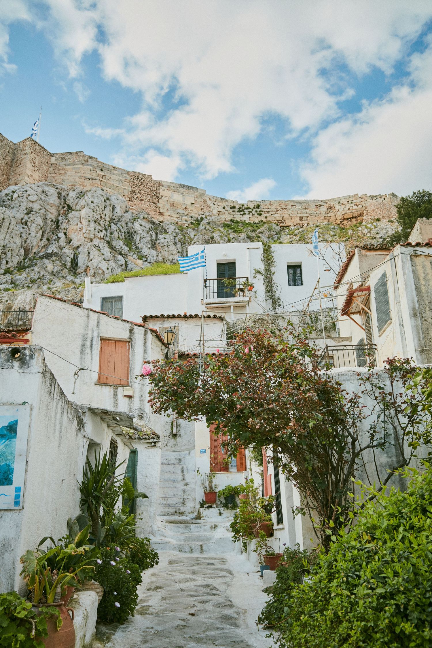 Whitewashed houses built into rocky cliffs with narrow winding stairs in Greece.