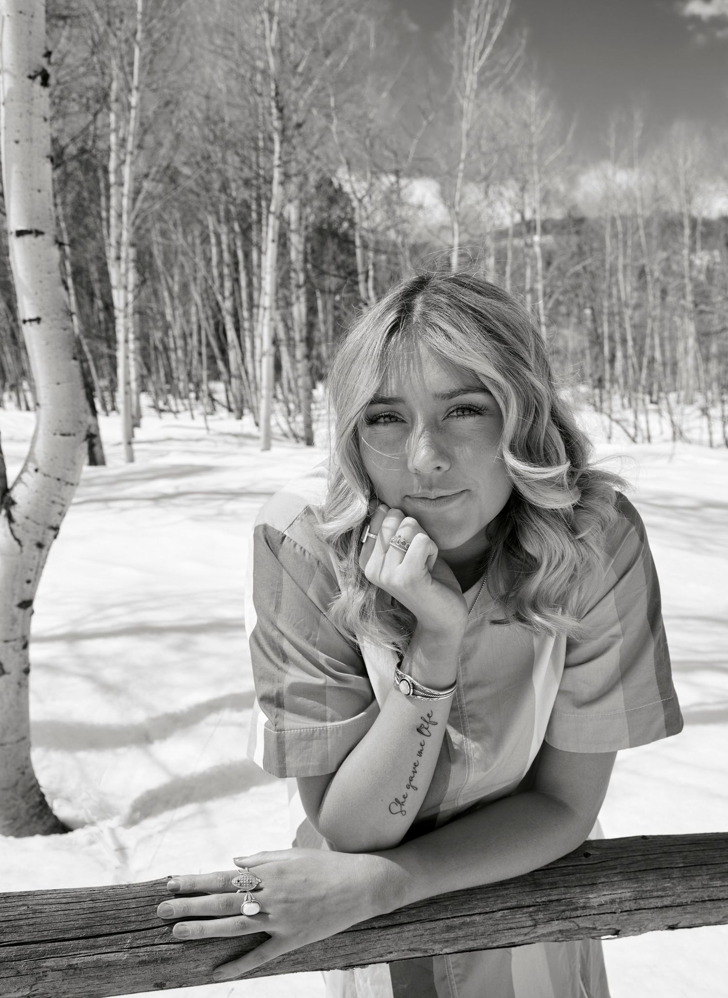 Black and white portrait in a snowy aspen grove featuring winter fashion and natural lighting.