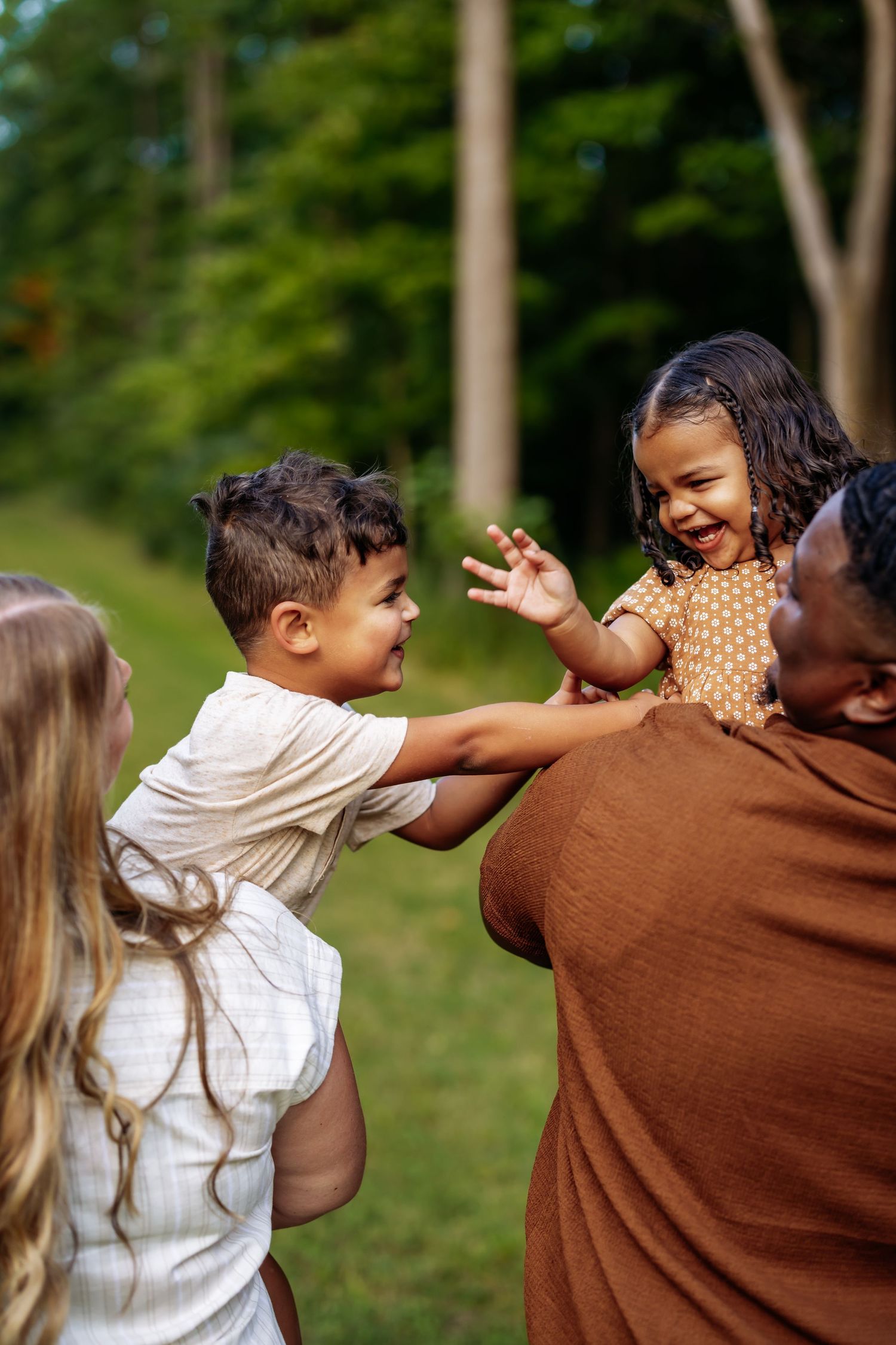 A sequence of four photos showing two people laughing and playfully interacting outdoors in a natural setting.