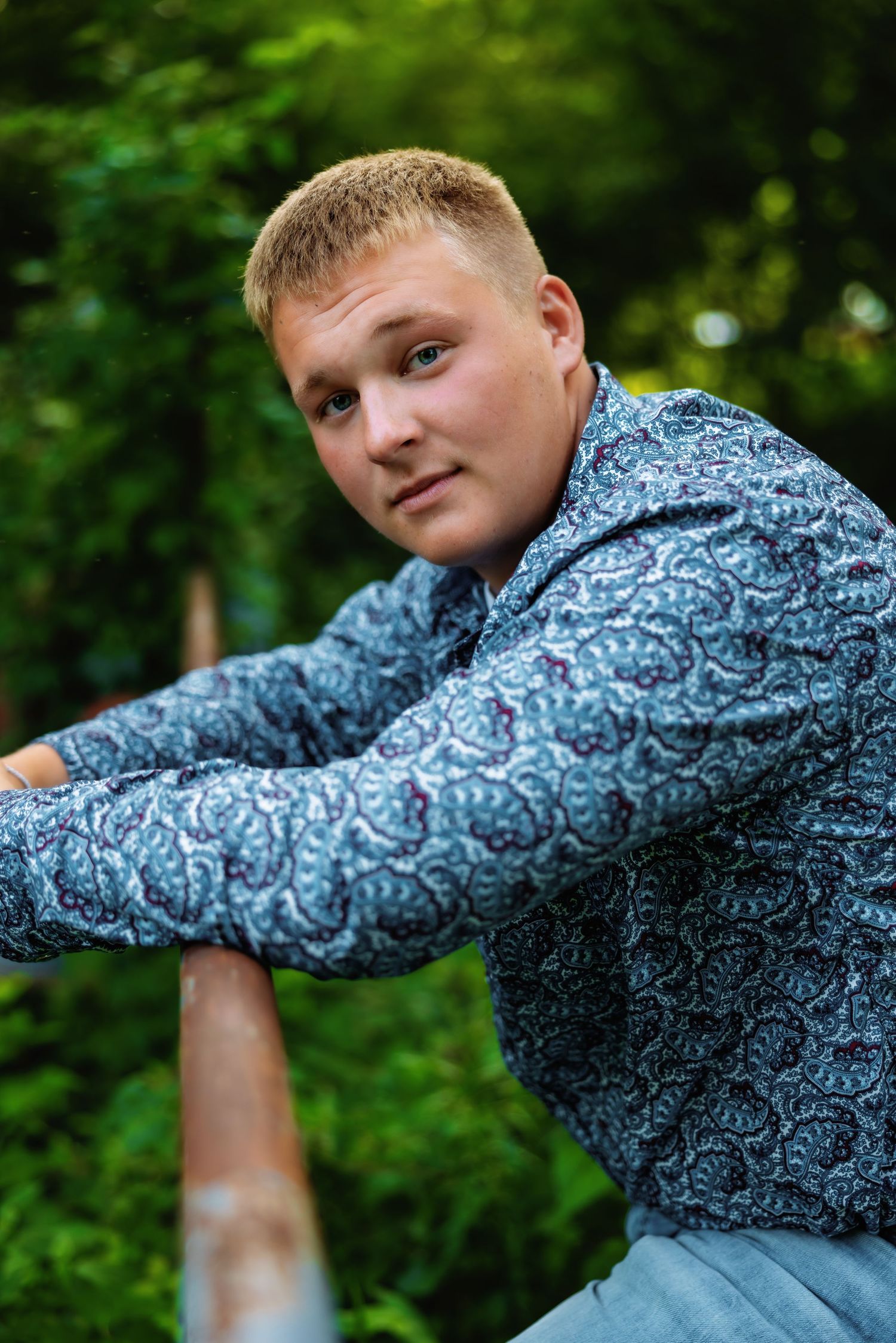 A series of five photos showing someone in a blue patterned shirt posing playfully against a green forest background.