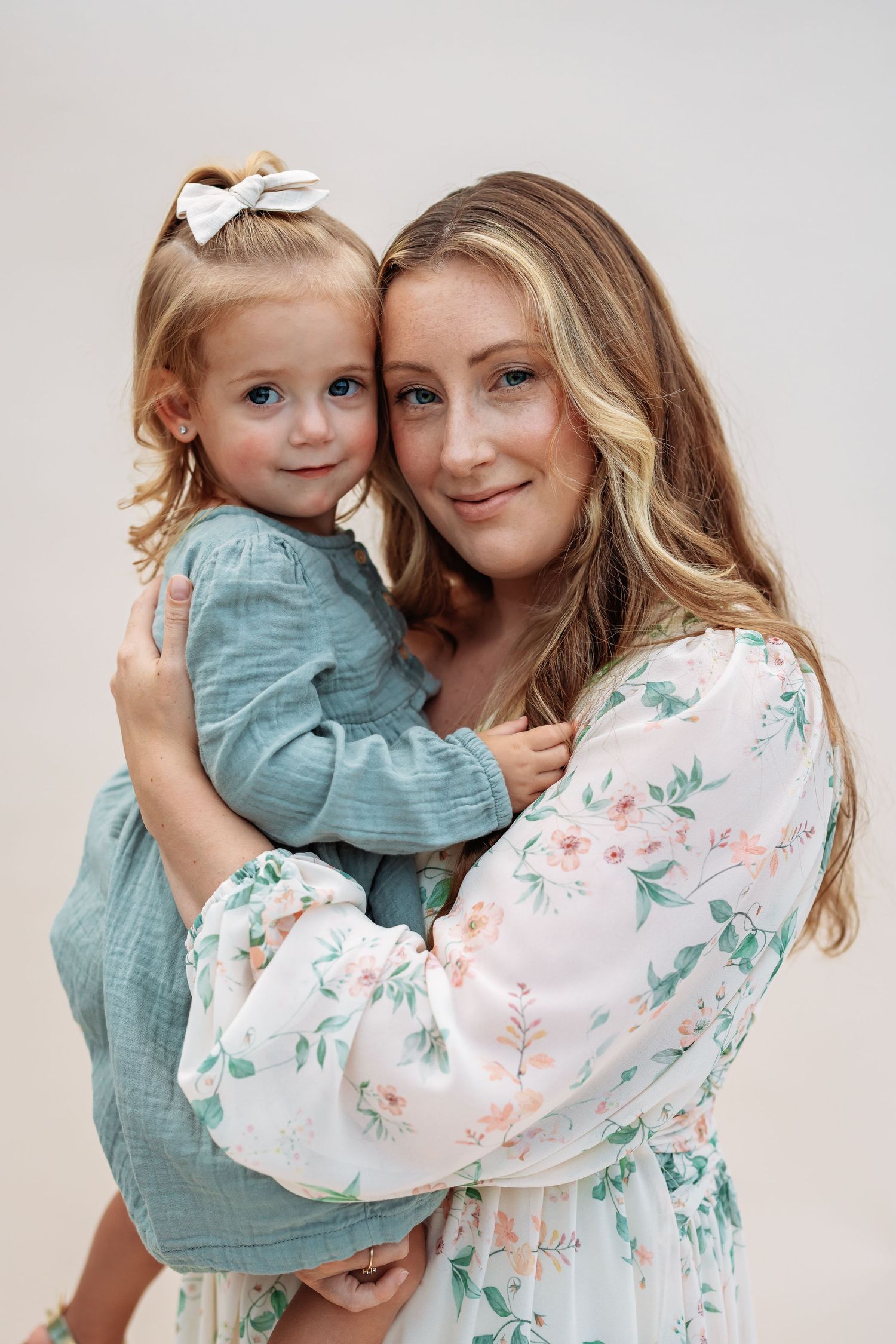 Portrait of parent and child in coordinating blue and floral outfits.