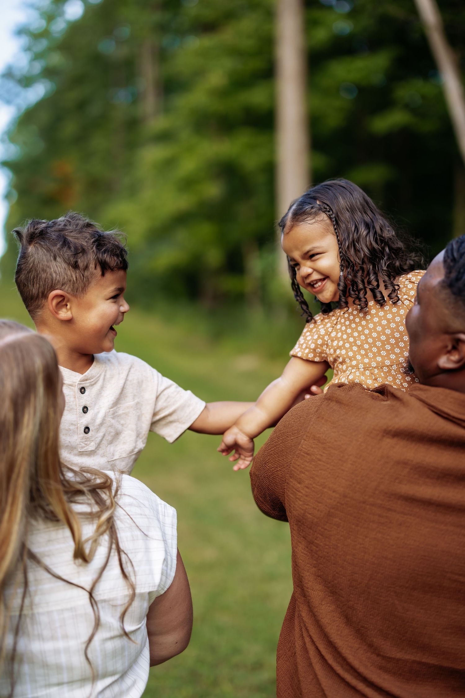 A playful sequence of candid outdoor family photos showing joyful interactions and laughter in a natural setting.