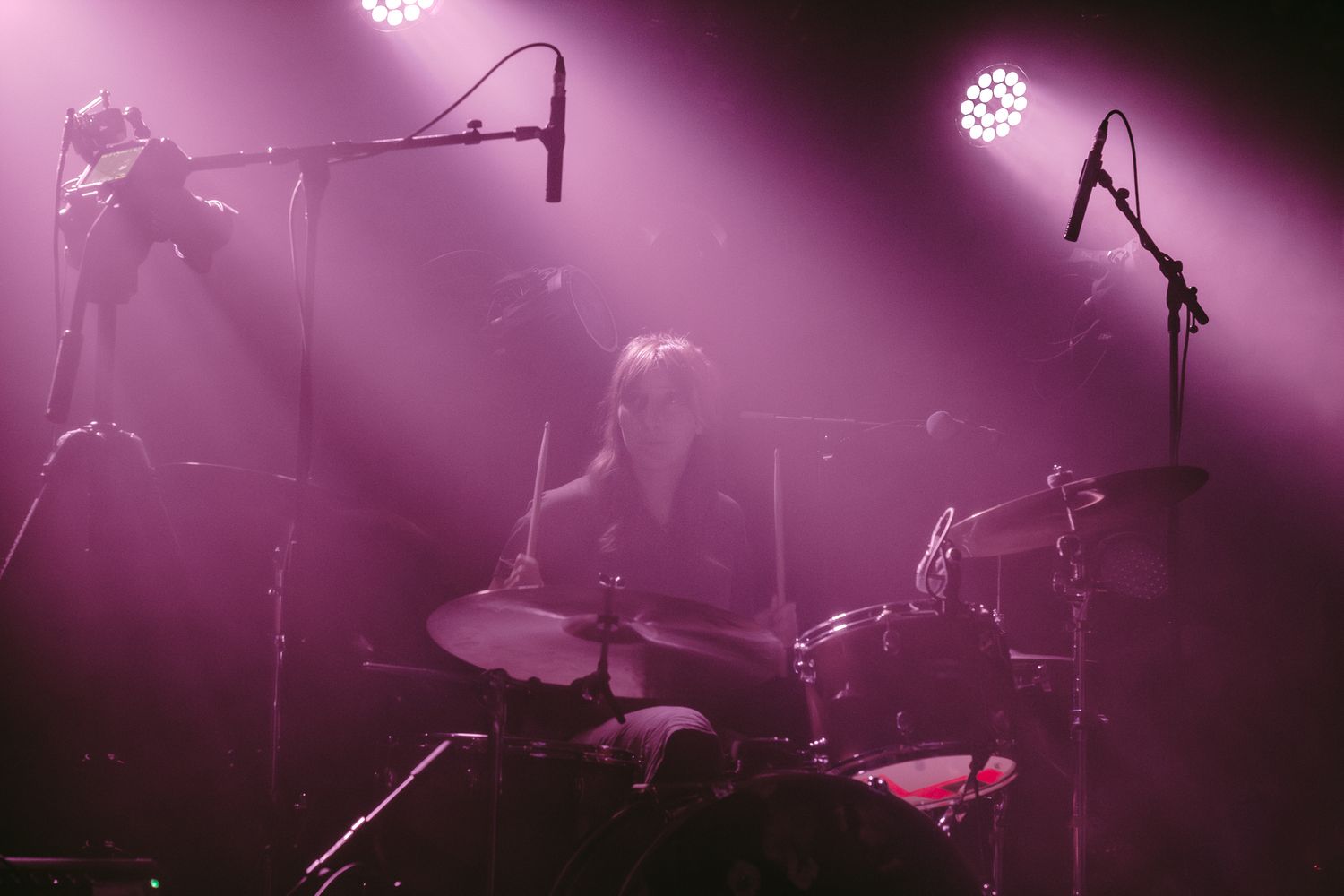 Photographie de concert par Mathieu Breton : batteuse sur scène dans une lumière violette.