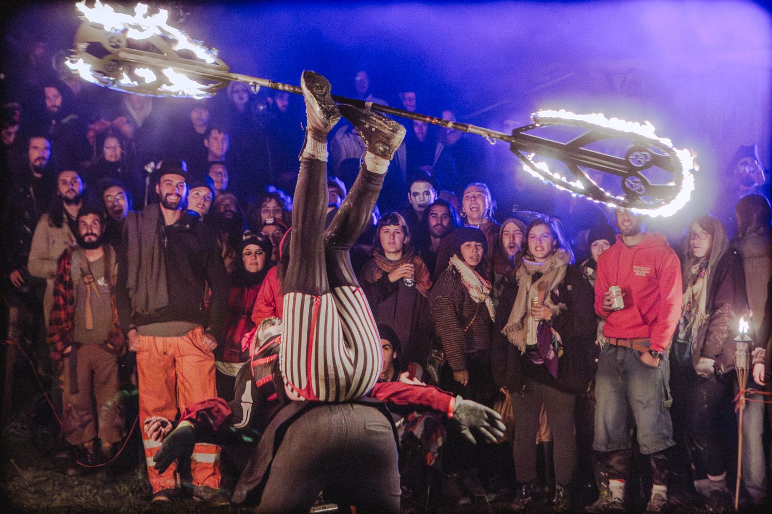 Photographie événementielle nocturne par Mathieu Breton : jongleur de feu en représentation devant un public.