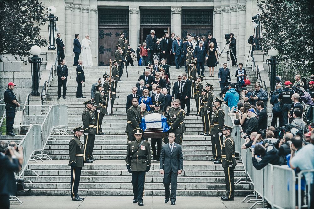 Photo historique captée par Mathieu Breton : cérémonie officielle avec cercueil de Jacques Parizeau devant une foule.