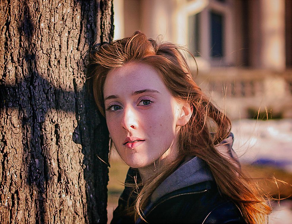 Portrait en lumière naturelle d’Ariane appuyée contre un arbre, capturé par Mathieu Breton à La Gaude.
