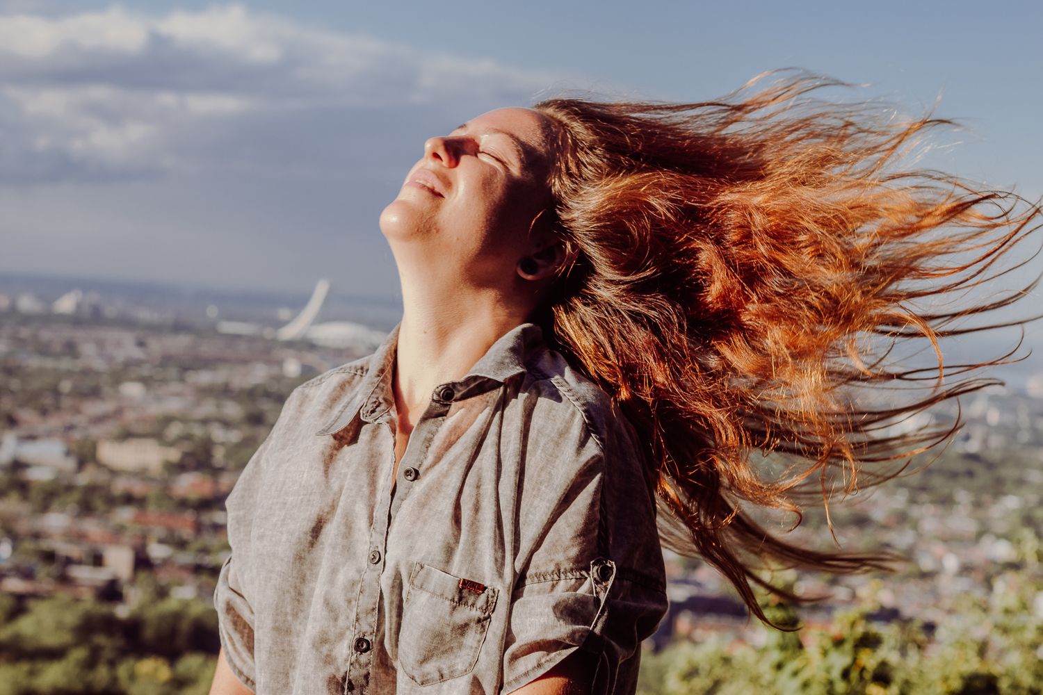 Portrait dynamique de Marine avec les cheveux au vent devant un paysage urbain, photo de Mathieu Breton à La Gaude.
