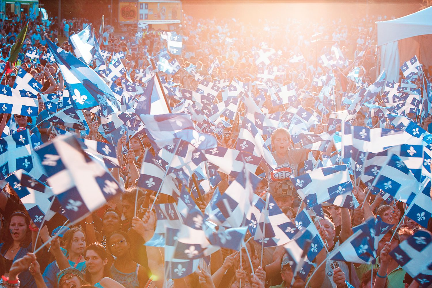 Photographie événementielle d’une foule brandissant des drapeaux bleu et blanc, captée par le photographe Mathieu Breton.