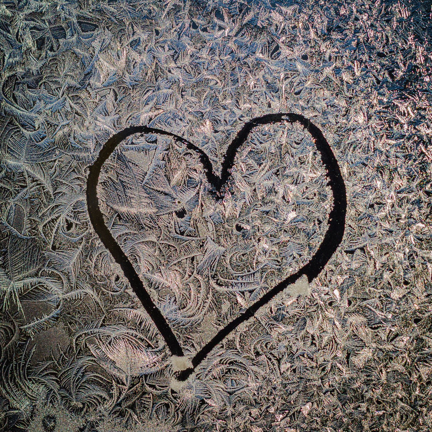 Photo artistique d’un cœur dessiné sur une surface gelée, réalisée par Mathieu Breton.