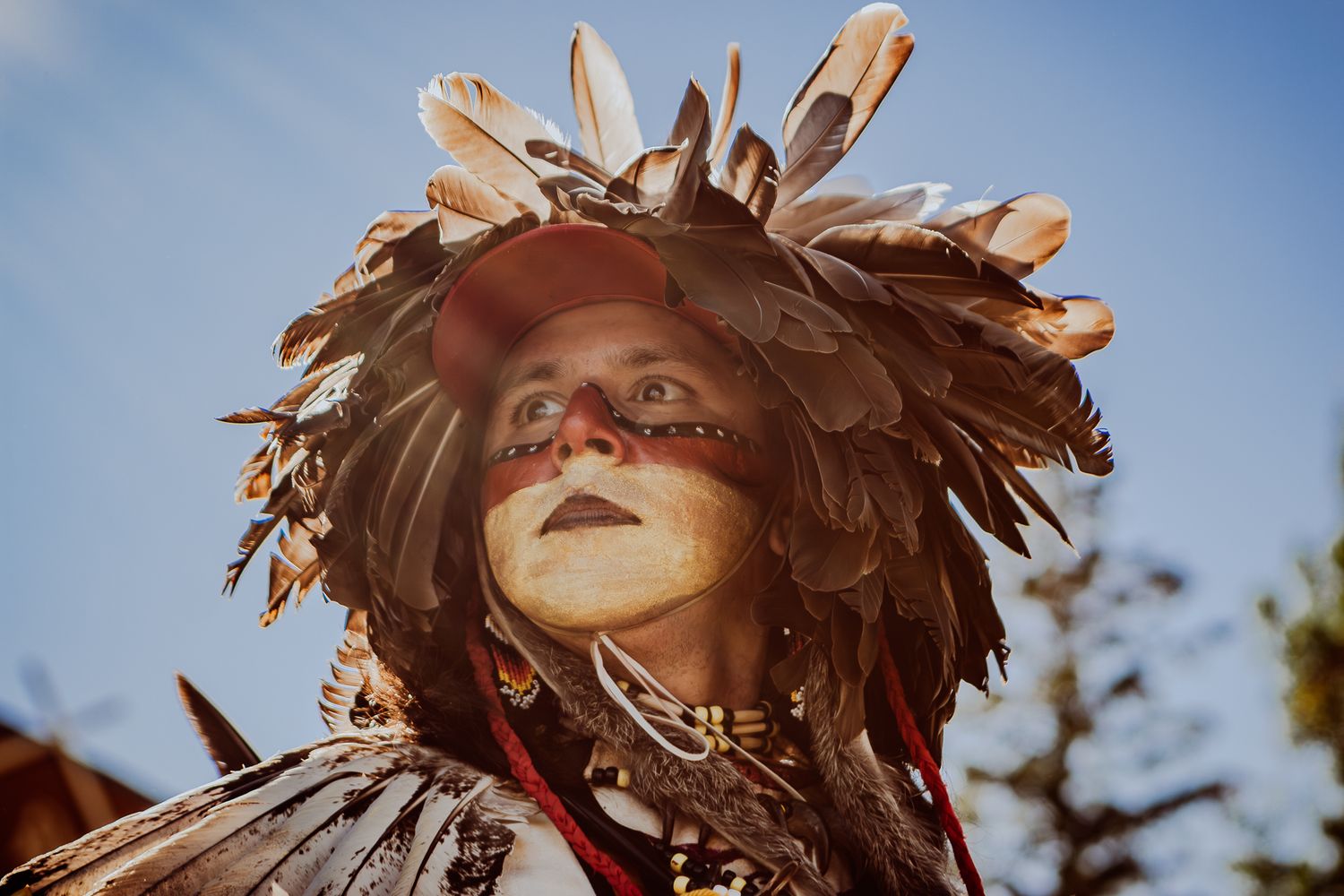 Portrait en gros plan d’un artiste autochtone en tenue traditionnelle, photographié par Mathieu Breton.