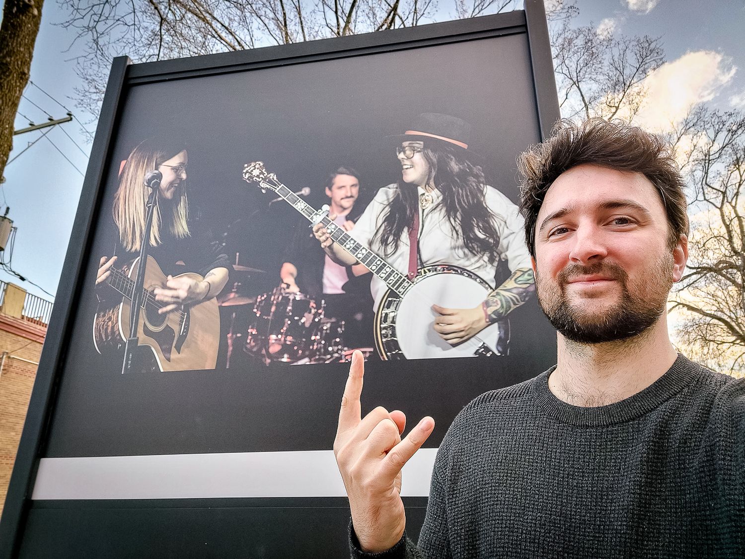 Photographe Mathieu Breton posant devant l’une de ses photos exposées en plein air à Québec.