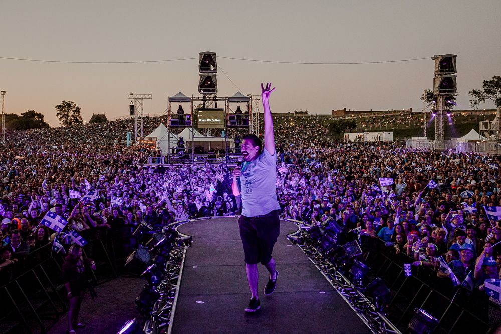 Photographie de scène par Mathieu Breton : foule en festival avec chanteur levant les bras.