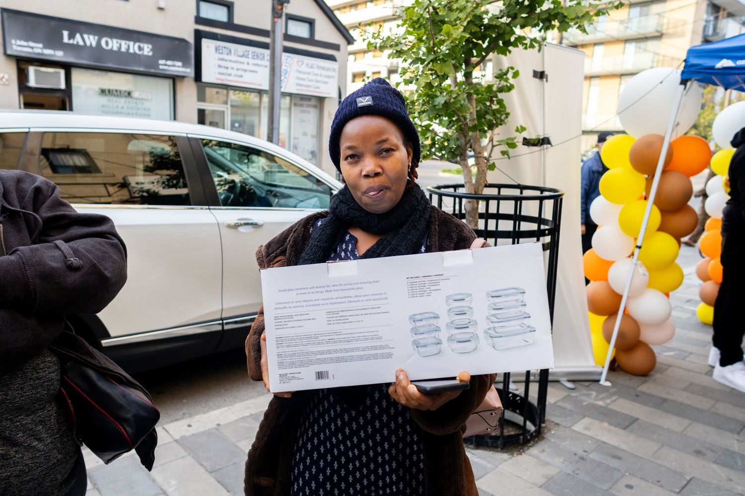 A document being displayed during an outdoor community gathering with balloon decorations.