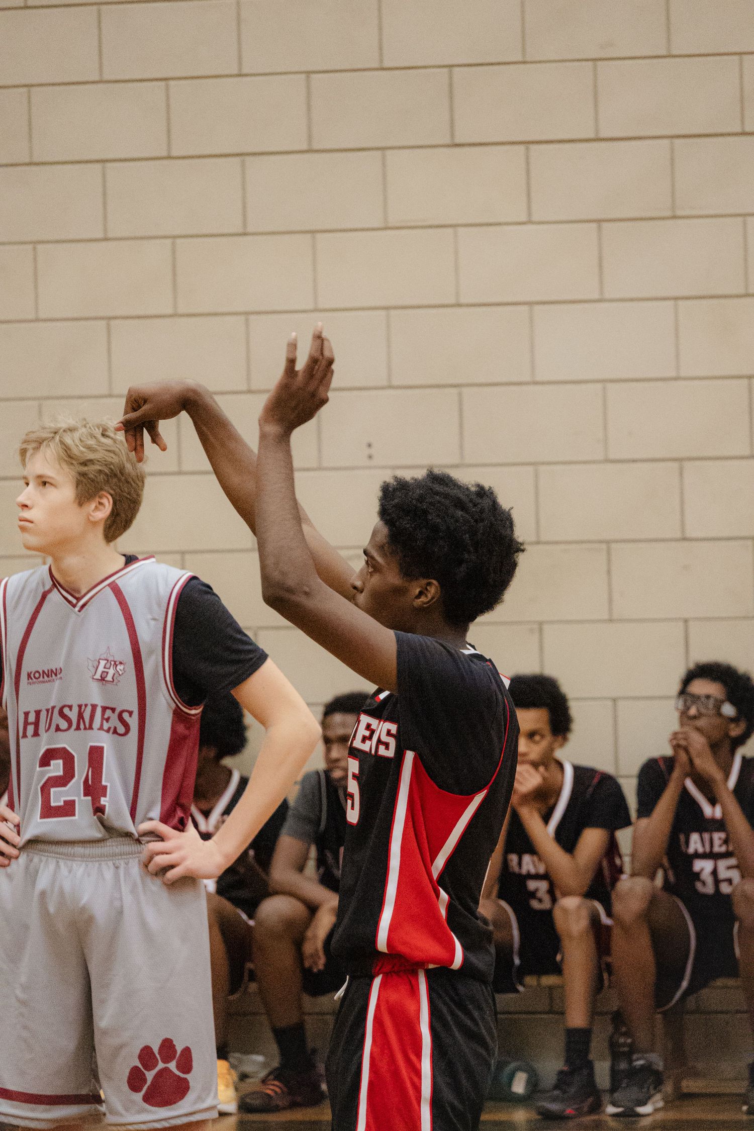 Basketball players positioning during game in school gymnasium.