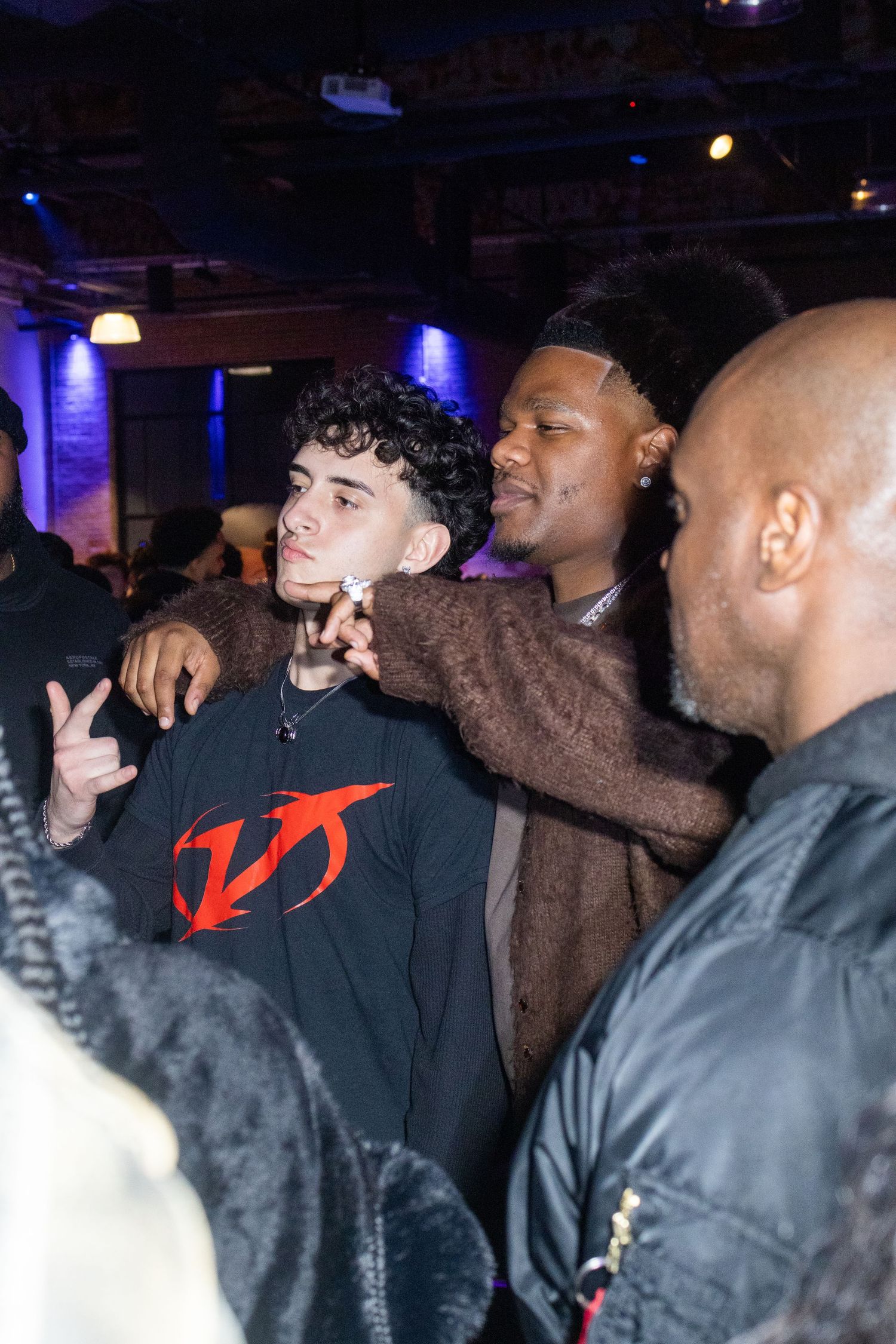 Energetic crowd enjoying music at nightclub with blue lighting.