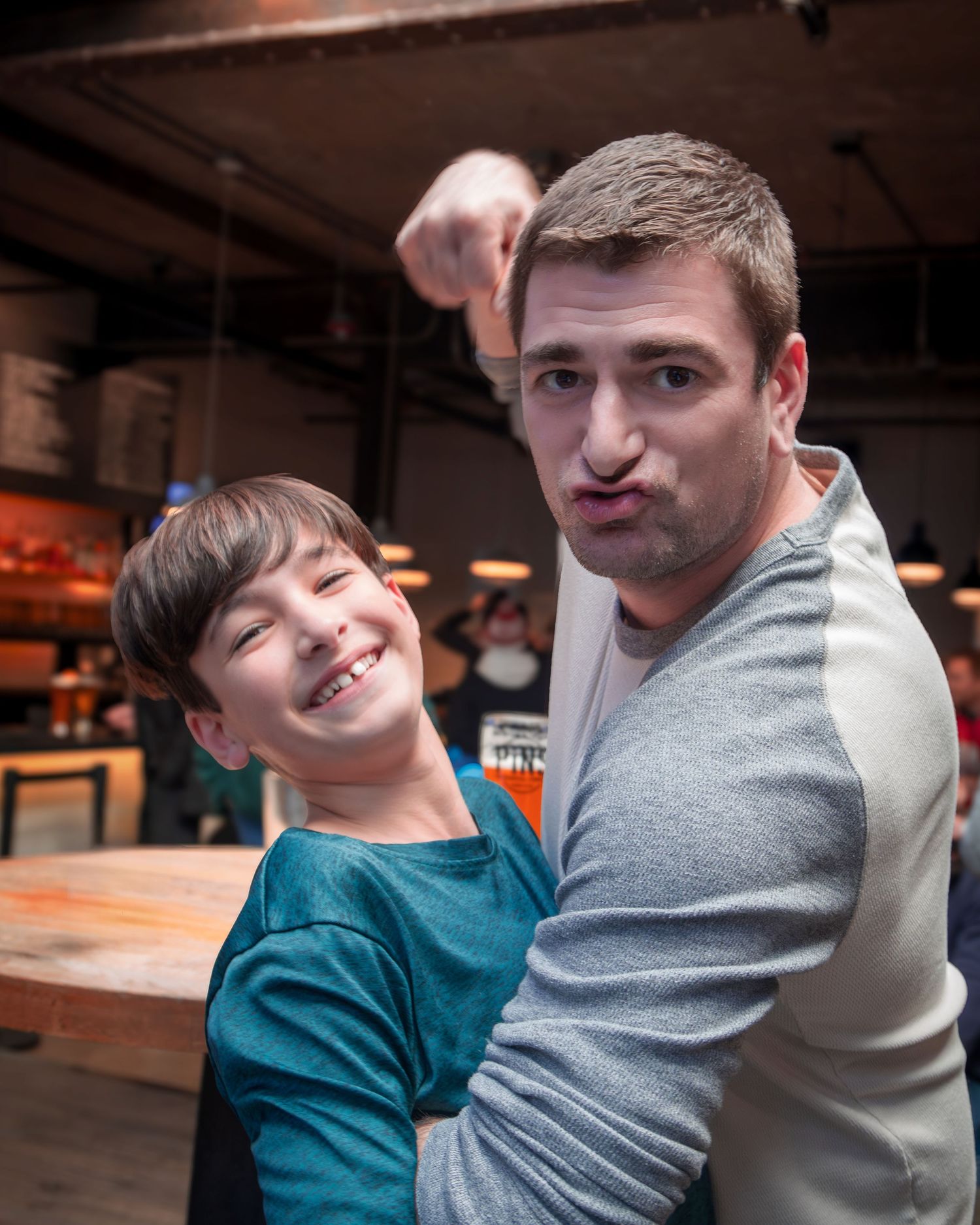 A playful parent and child moment captured in an indoor setting wearing casual attire.