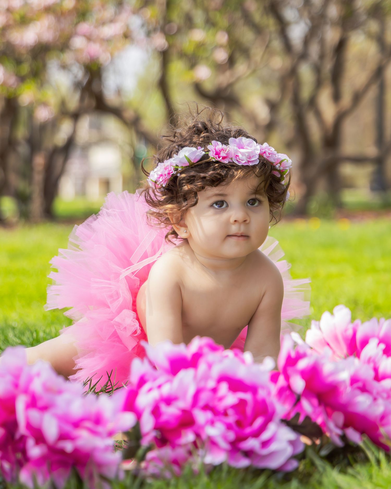 Pink peonies frame a magical spring portrait featuring a floral crown and bright tulle tutu.