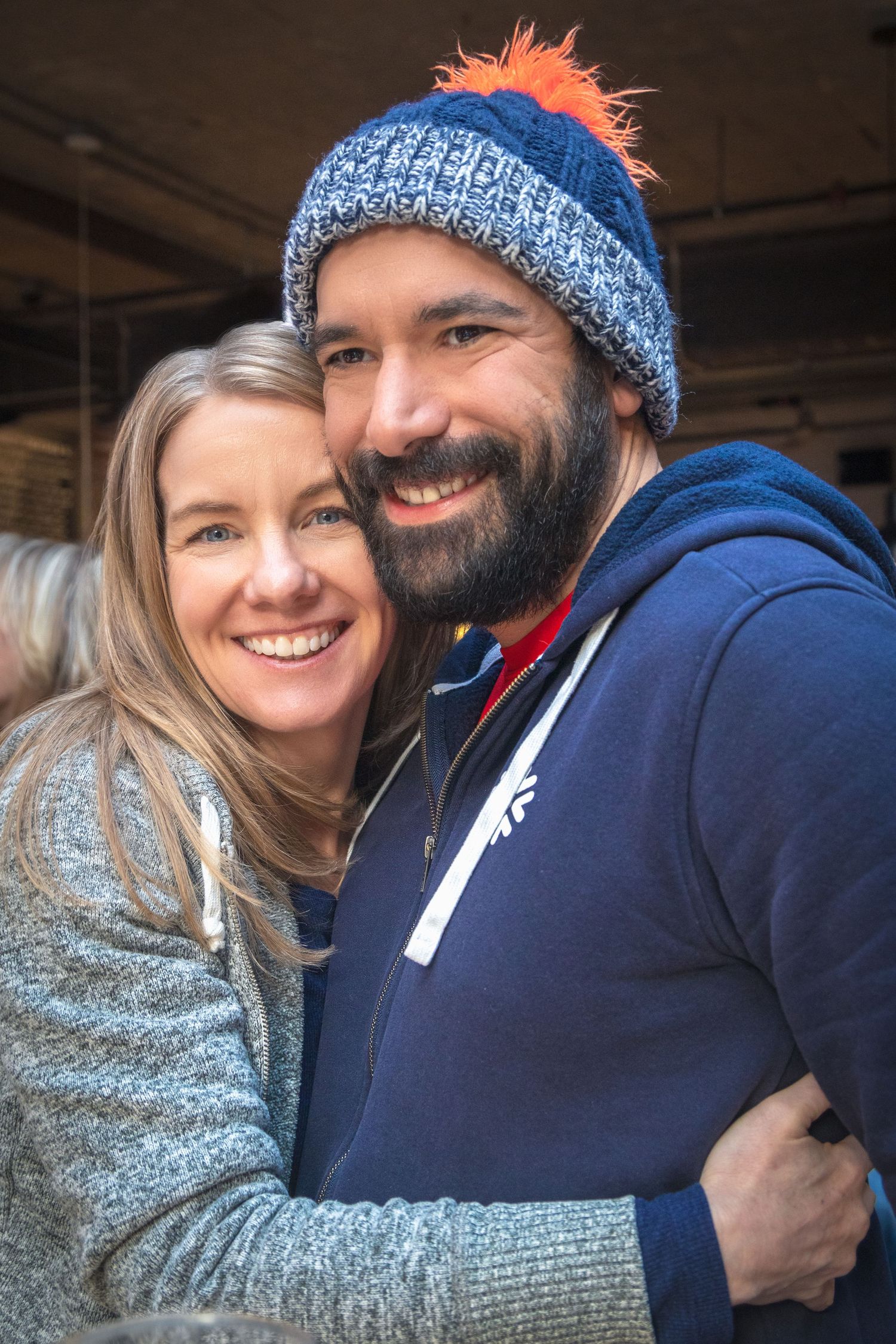 Happy couple in winter attire sharing an intimate moment and genuine smiles.