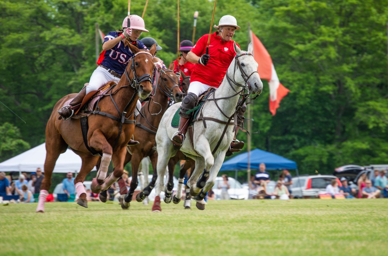 Multiple polo players on horseback competing in an intense polo match outdoors.