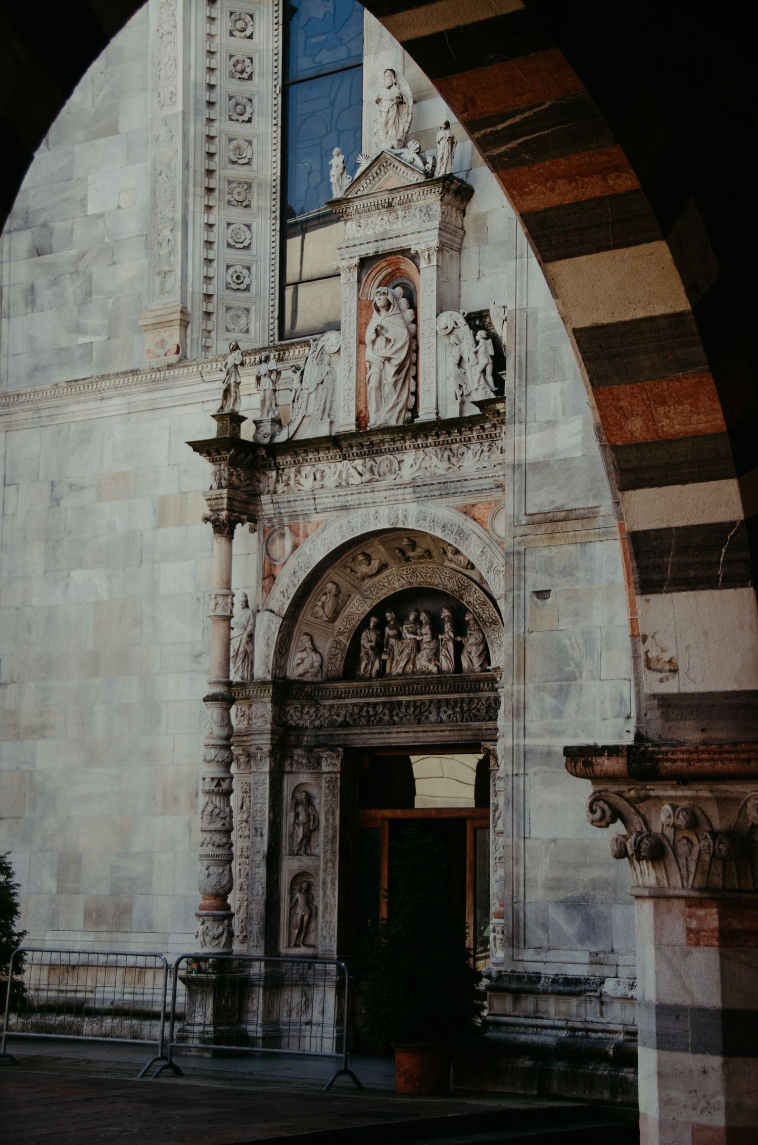 Ornate stone entrance of a historic church with detailed carvings and religious statues.