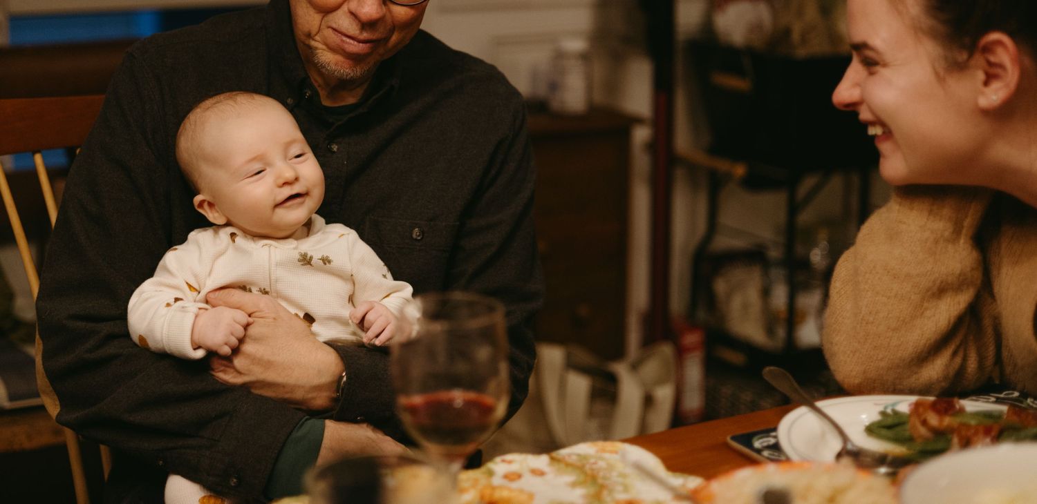A warm family moment around a dining table with a baby during mealtime.
