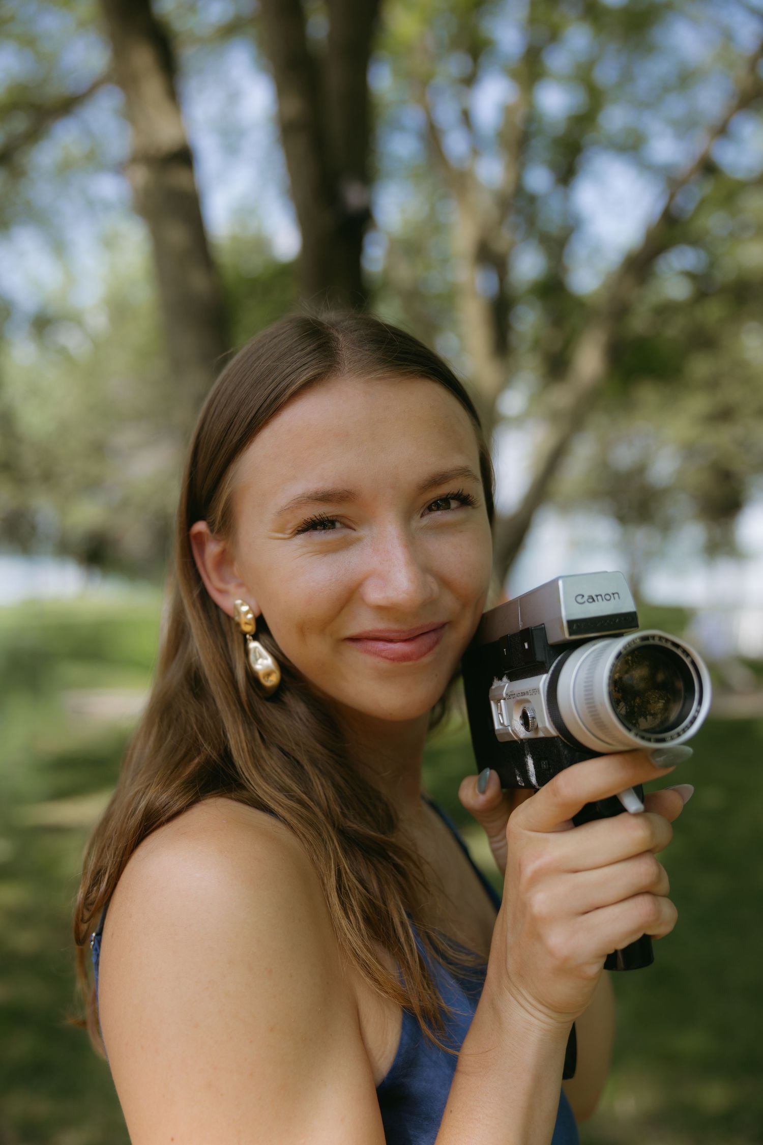 A sequence of five similar photos showing someone holding a vintage camera in a sunny outdoor setting with trees.