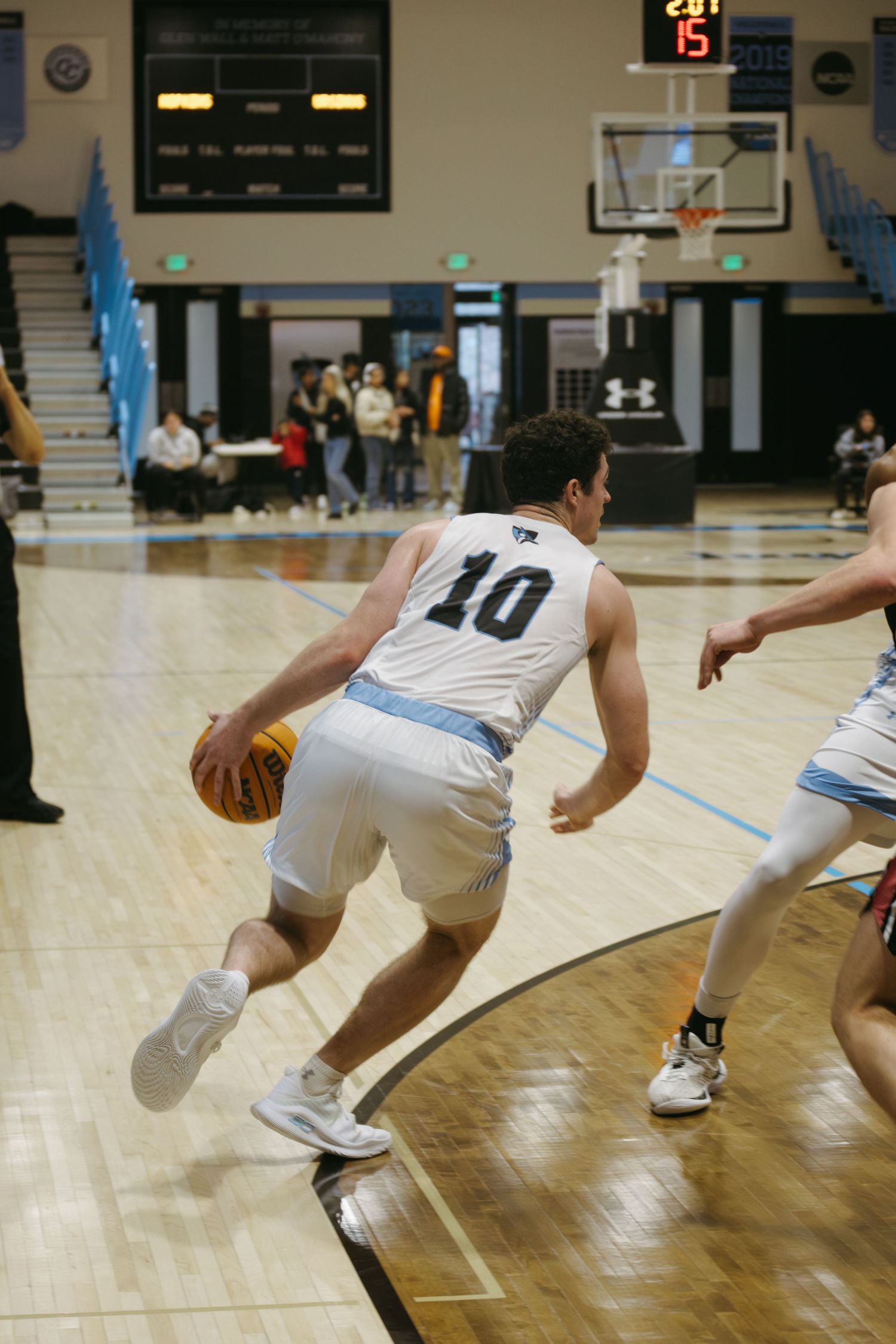 Basketball player in white jersey number 40 dribbling on an indoor court during a game.