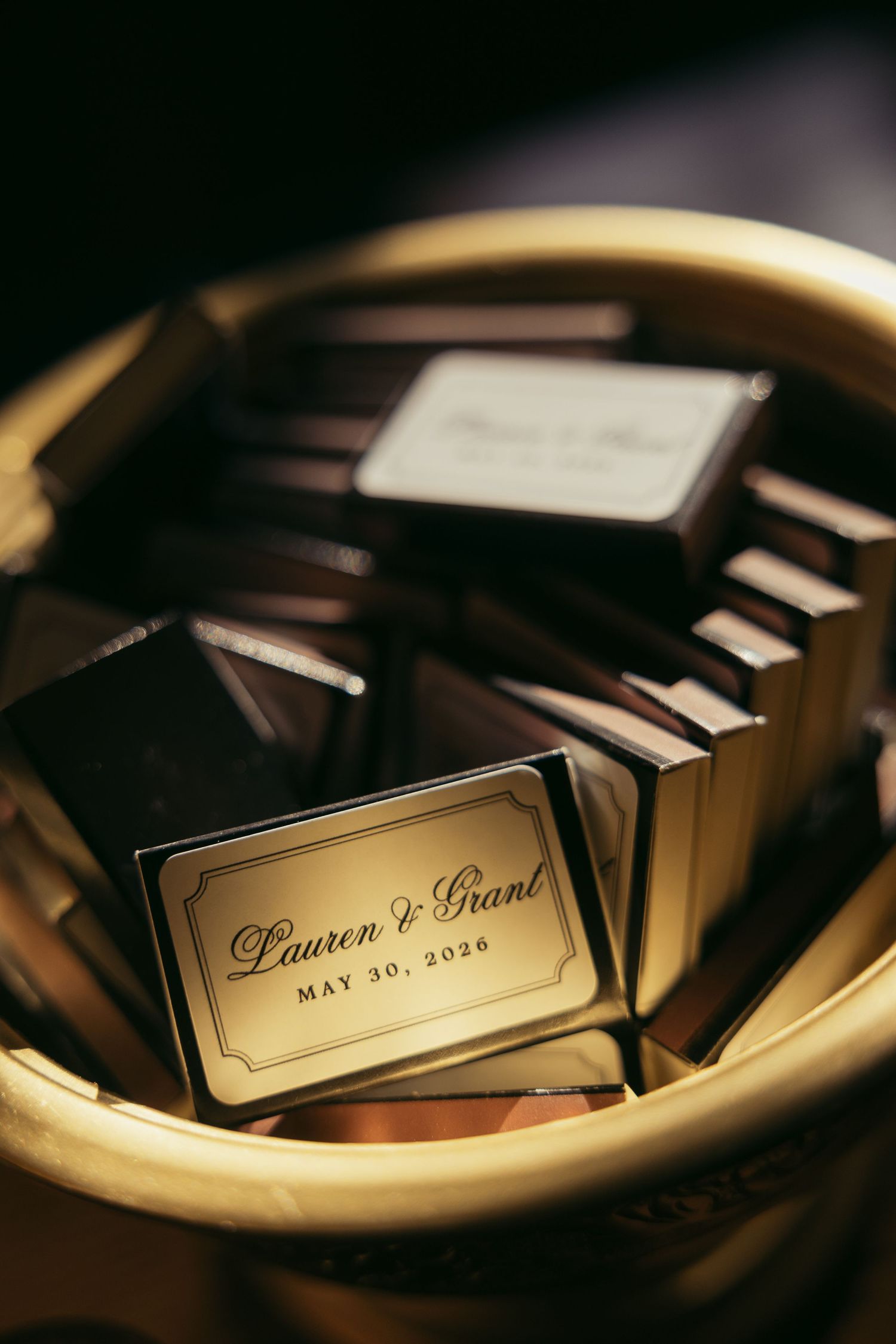 Personalized gold chocolate wedding favors for Lauren and Grant, dated May 30, 2026, displayed in a golden basket.