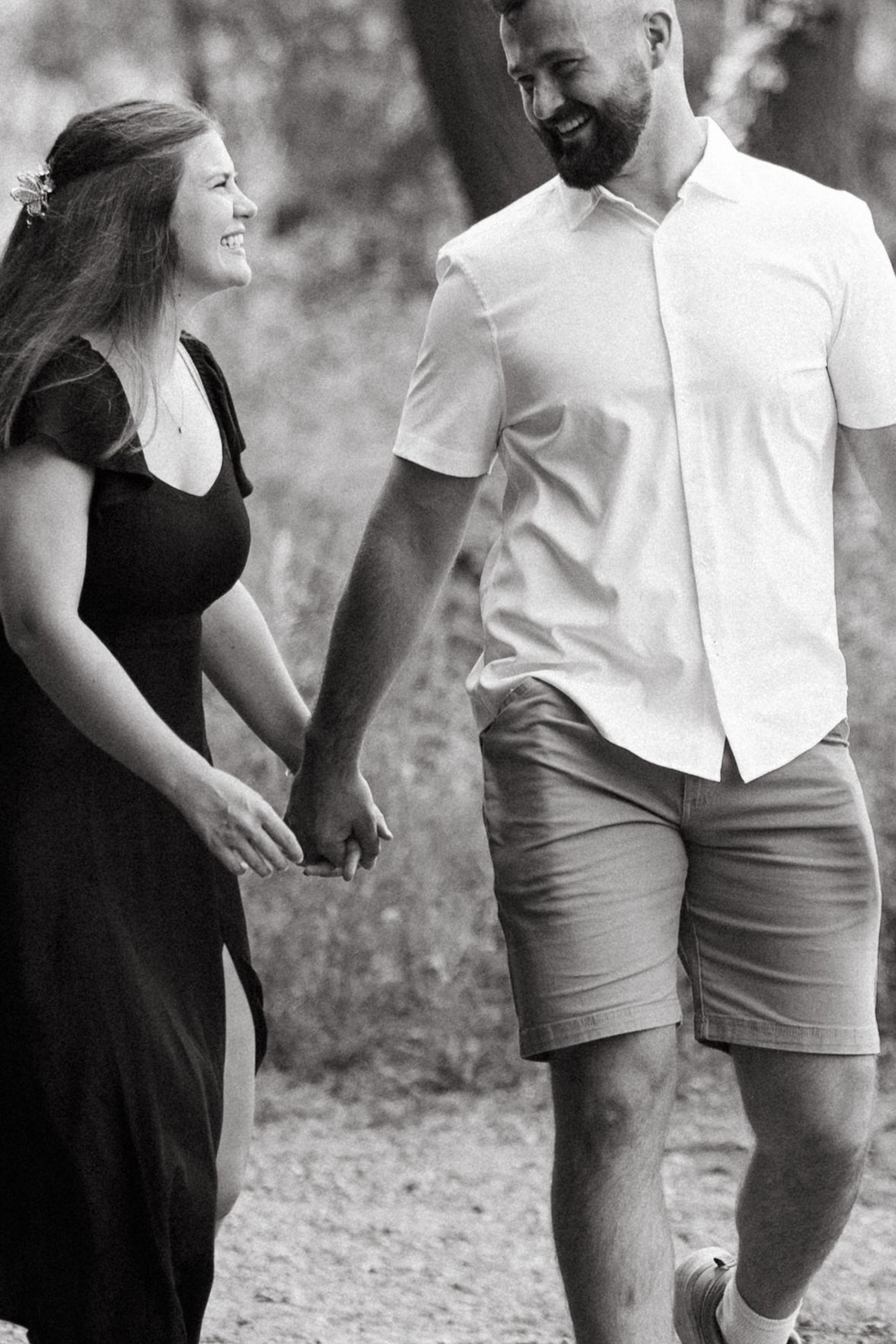 Black and white maternity photo sequence showing a couple laughing together while standing outdoors.