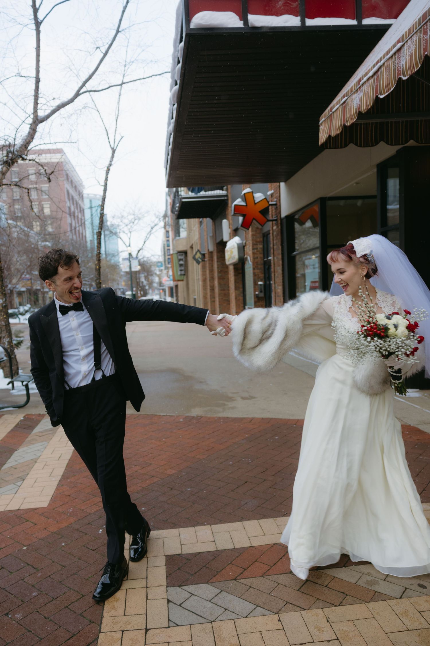 A playful sequence of wedding photos showing the couple dancing and twirling on a brick sidewalk in winter.