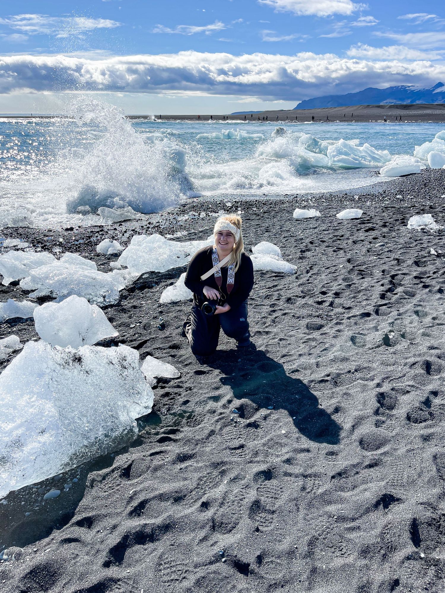 A series of photos showing someone posing next to large chunks of glacial ice on a black sand beach in Iceland.