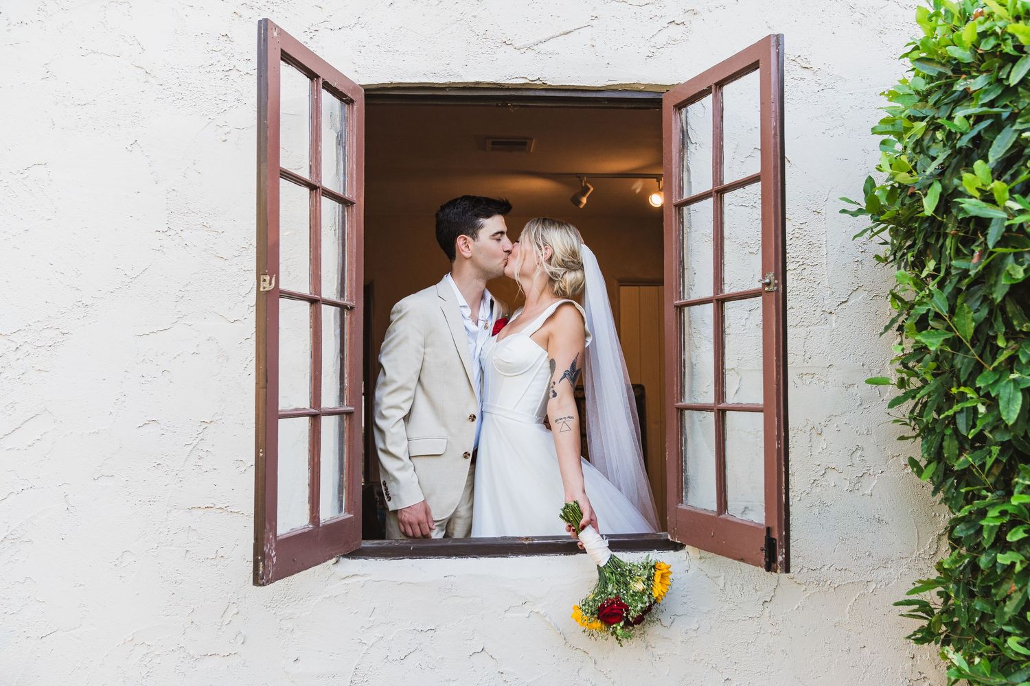 A romantic couple shares tender moments through a rustic window frame in a series of wedding photographs.