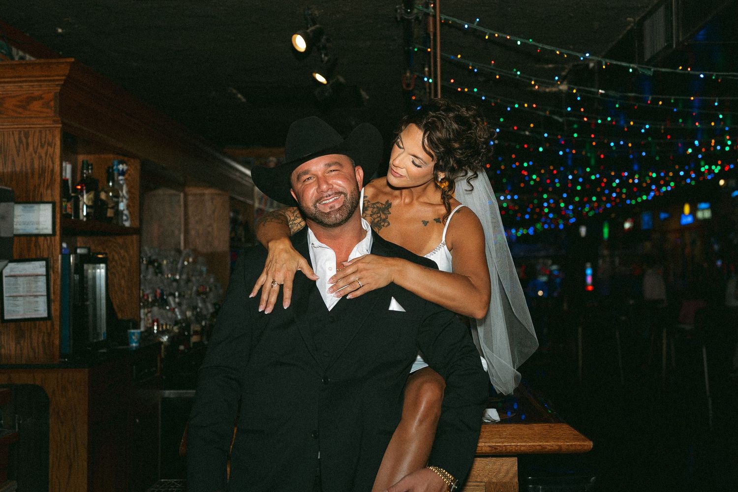 couple celebrating their elopement in nashville tennessee, taken with flash in a bar. girl sitting on bar. nashville elopement photographer