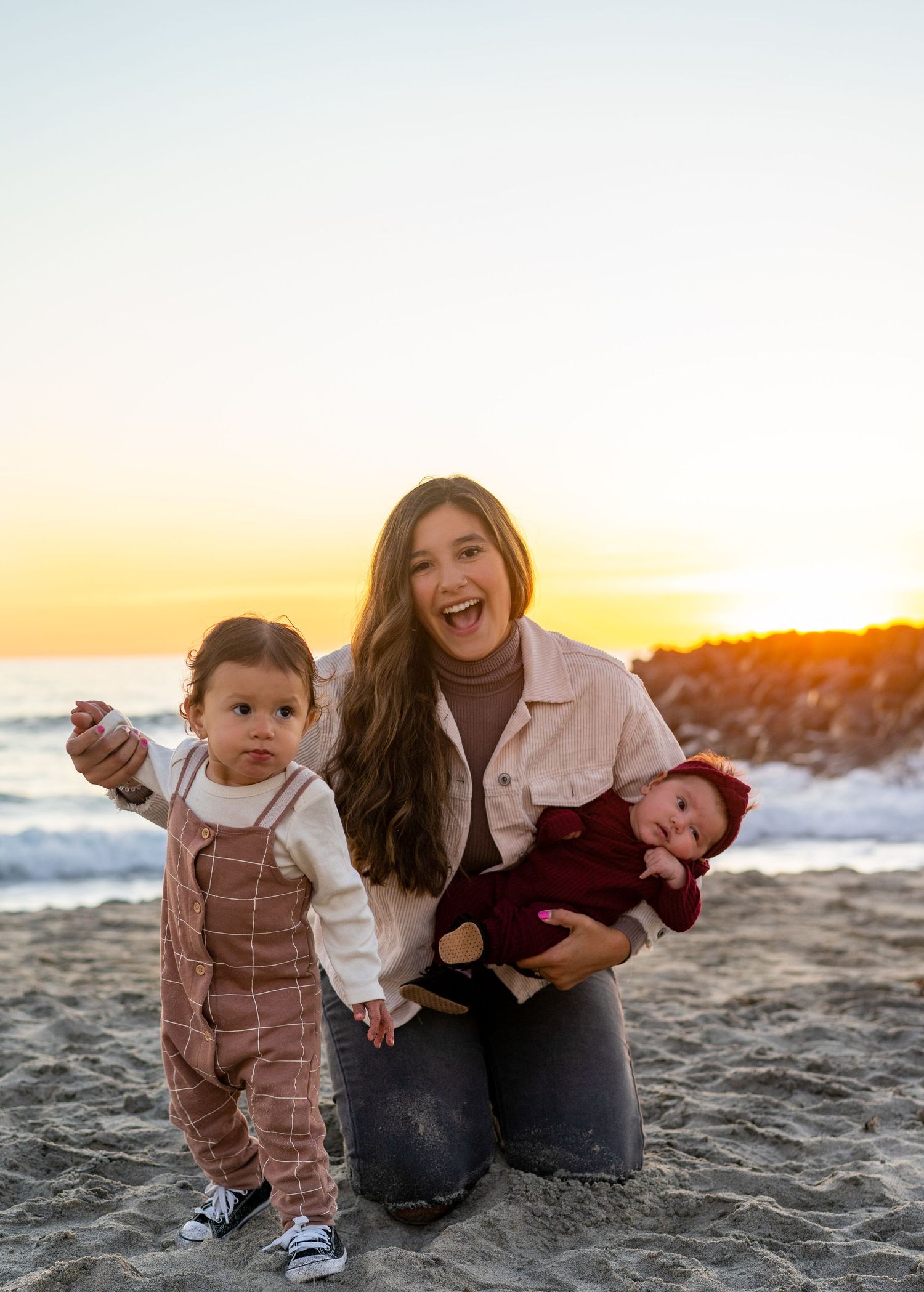 Family enjoying a sunset moment together on a sandy beach.
