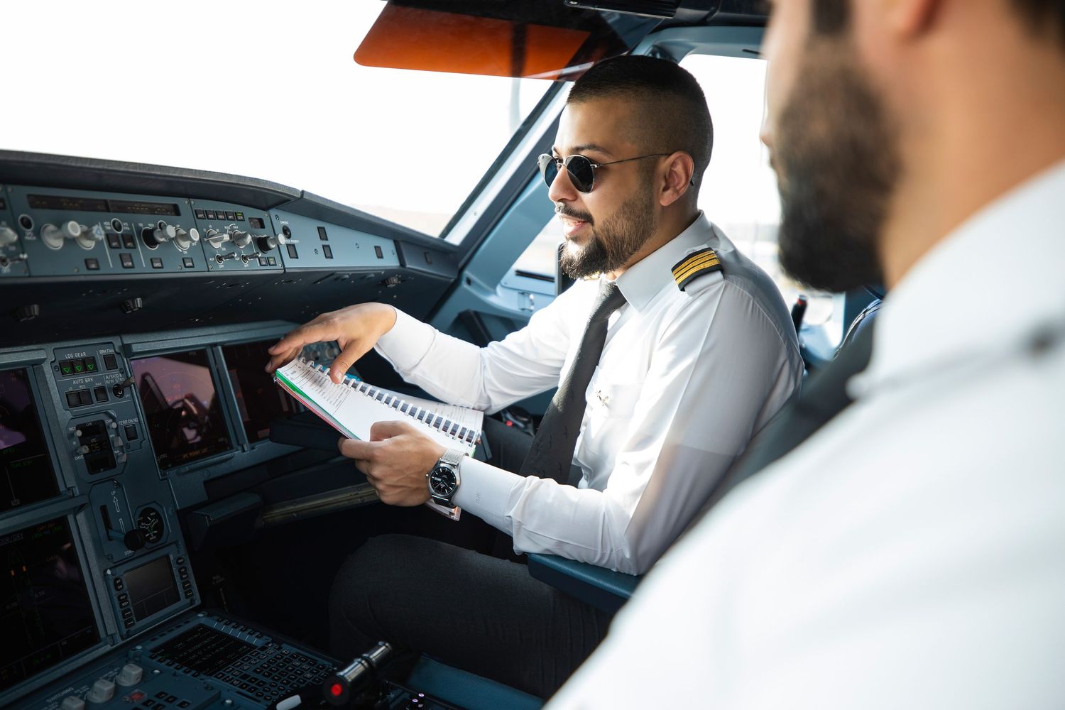 Cockpit briefing photo – pilots reviewing flight checklist documents before departure