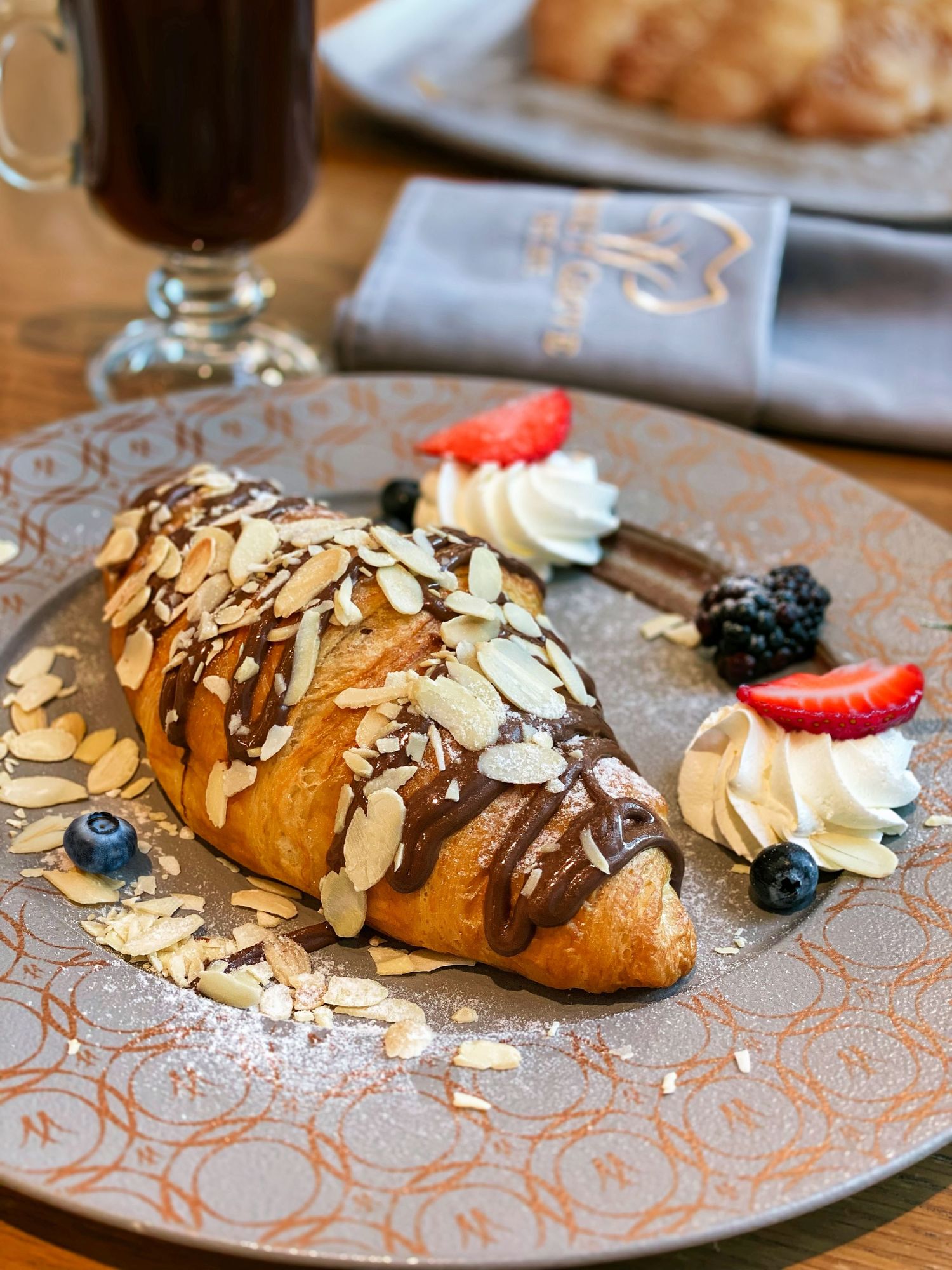 French bakery photography of chocolate-drizzled croissant, suitable for promotional visual content.