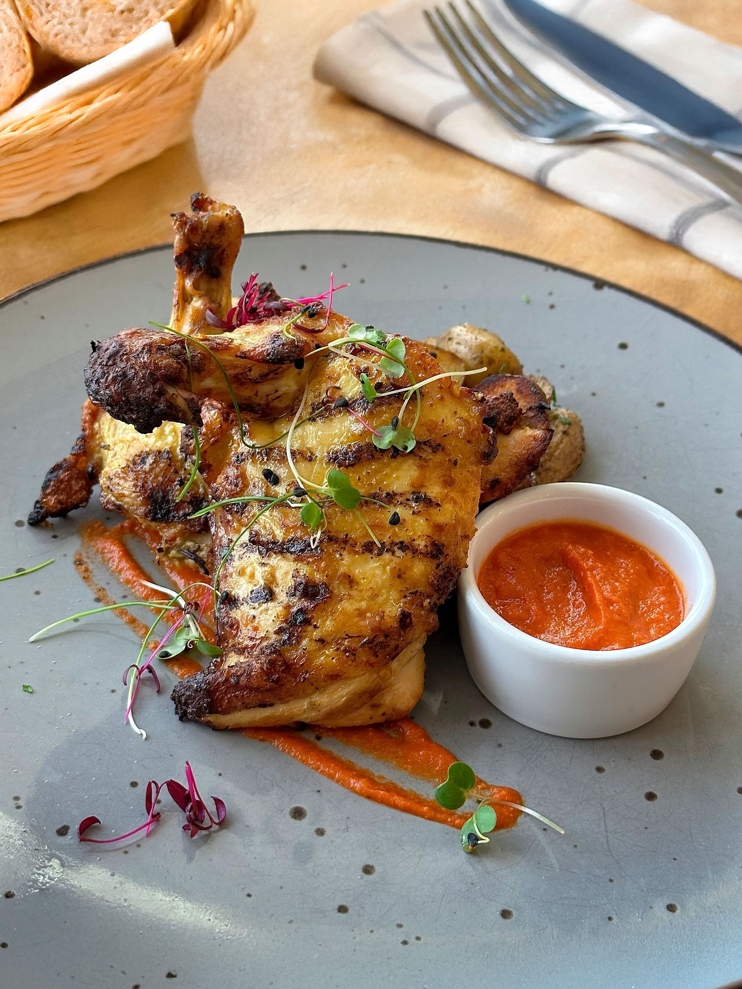Roasted chicken entre with orange glaze and dipping sauce captured for restaurant food photography and video content.