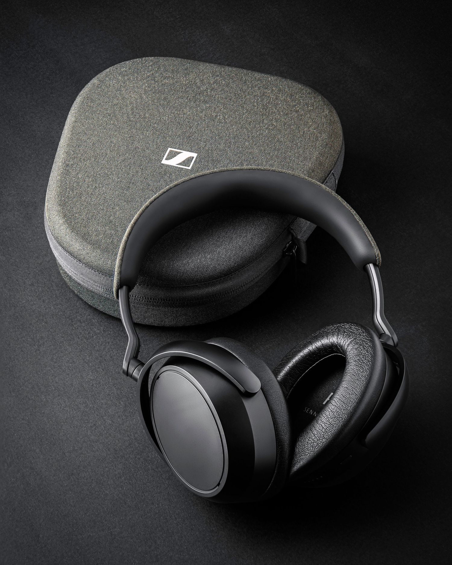 Professional black Sennheiser wireless headphones shown from multiple angles on dark background.