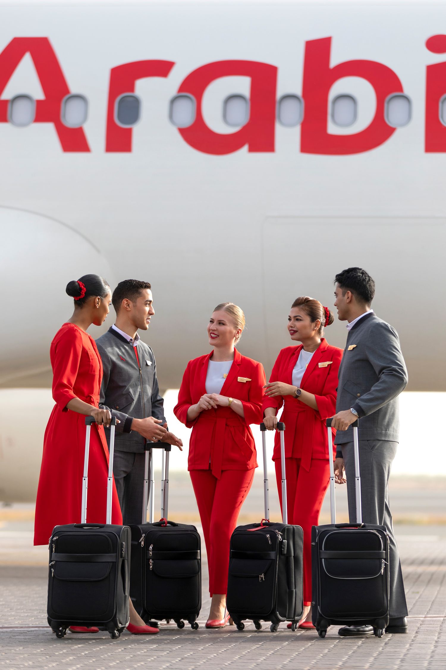 Airline crew in uniform with luggage beside an aircraft on the runway, captured for branded airline photography and operational video.
