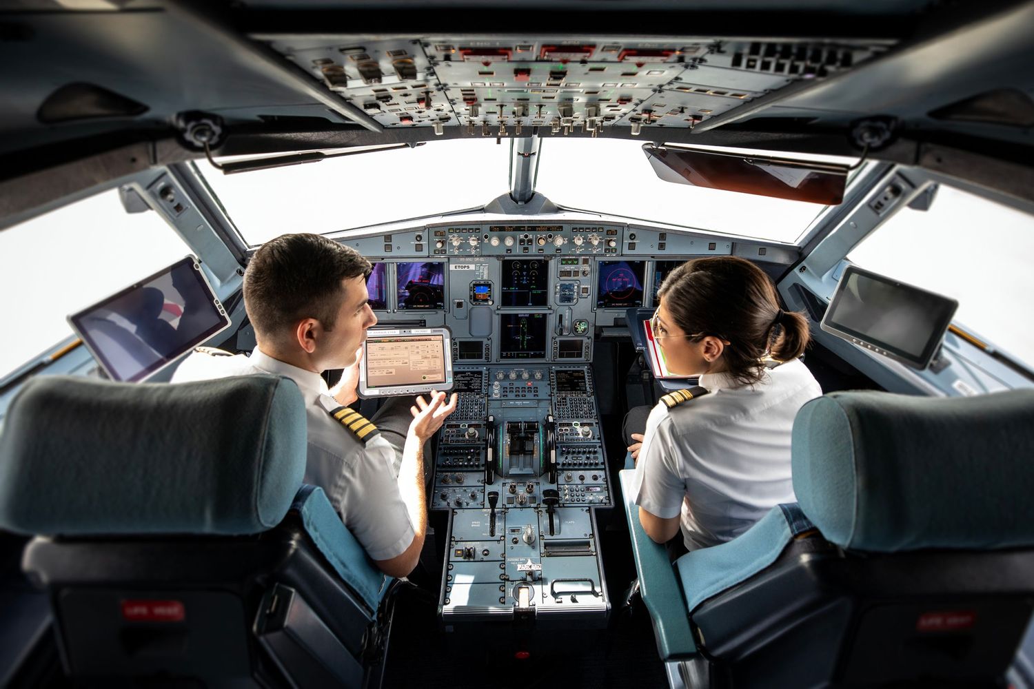 Commercial aviation photography showcases two pilots in a modern cockpit, captured for branded airline photography and video.