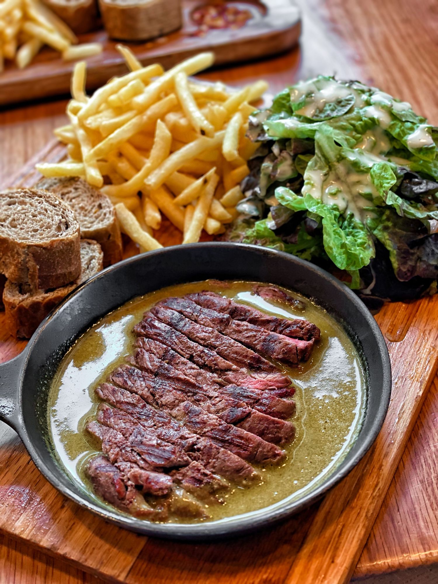 Premium food photography featuring grilled steak served with fries and a salad, styled for commercial photography and video content.