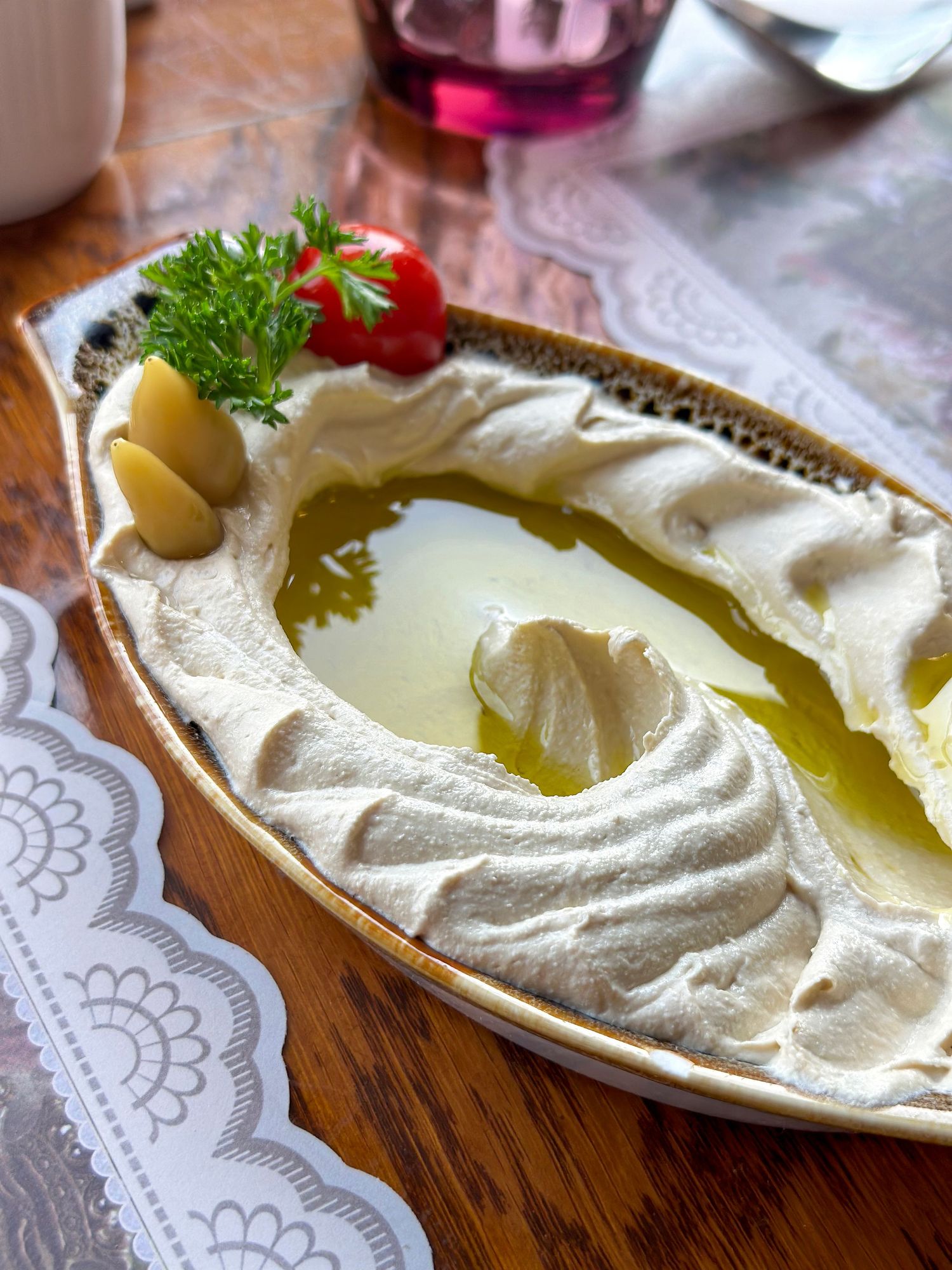 Middle Eastern food photography of traditional hummus with tomato, styled for commercial and short-form video content.