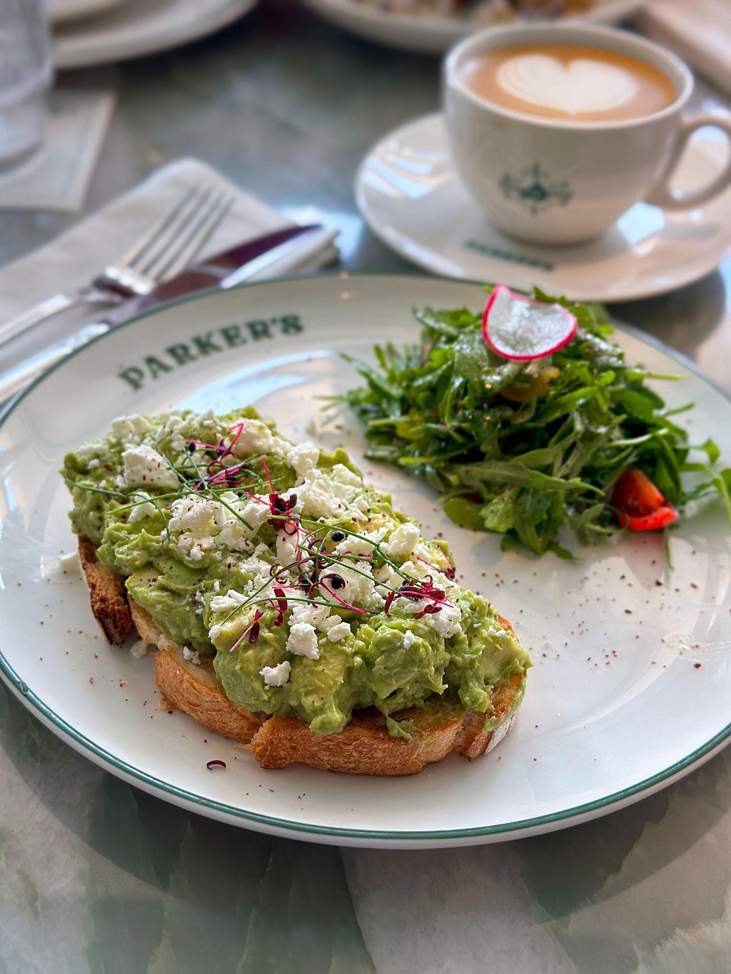 Cafe visual content of healthy avocado toast with microgreens and coffee.