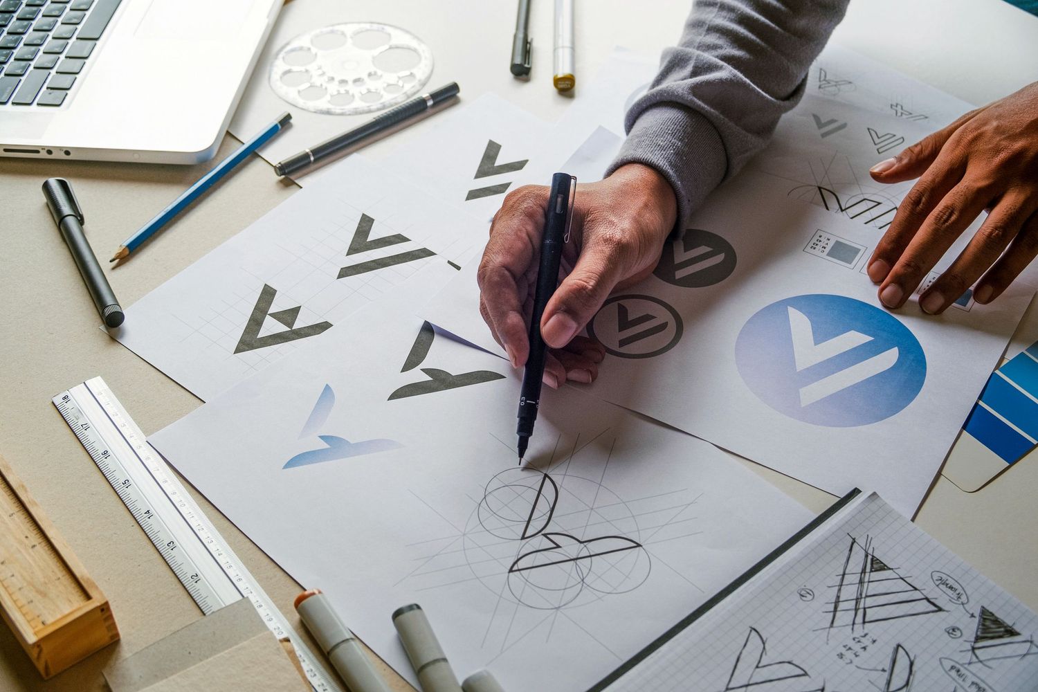 Logo concept sketching for brand design – graphic designer at work on white desk