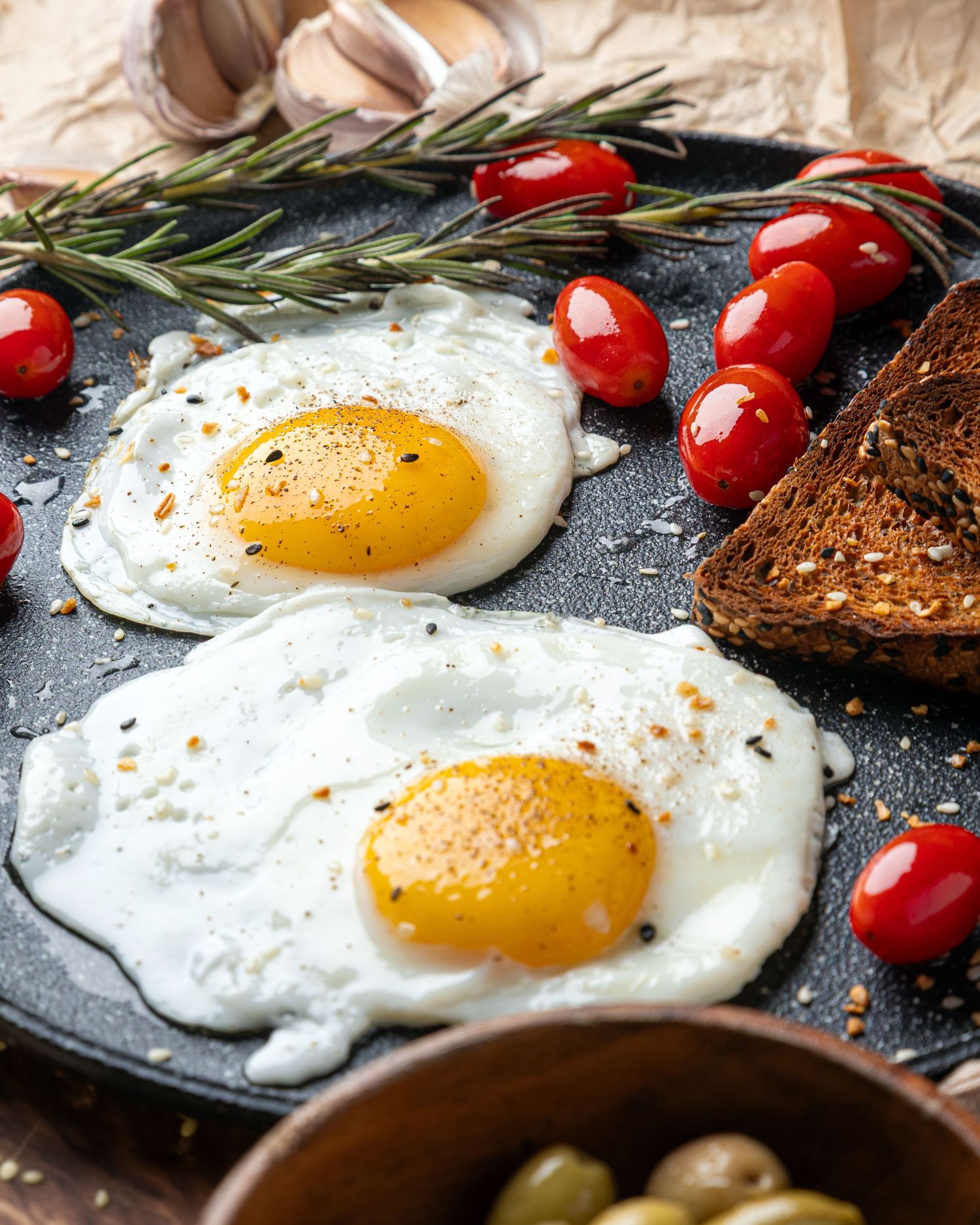 Rustic breakfast food content showcasing fried eggs with rosemary and toast, styled for use in photography and video.