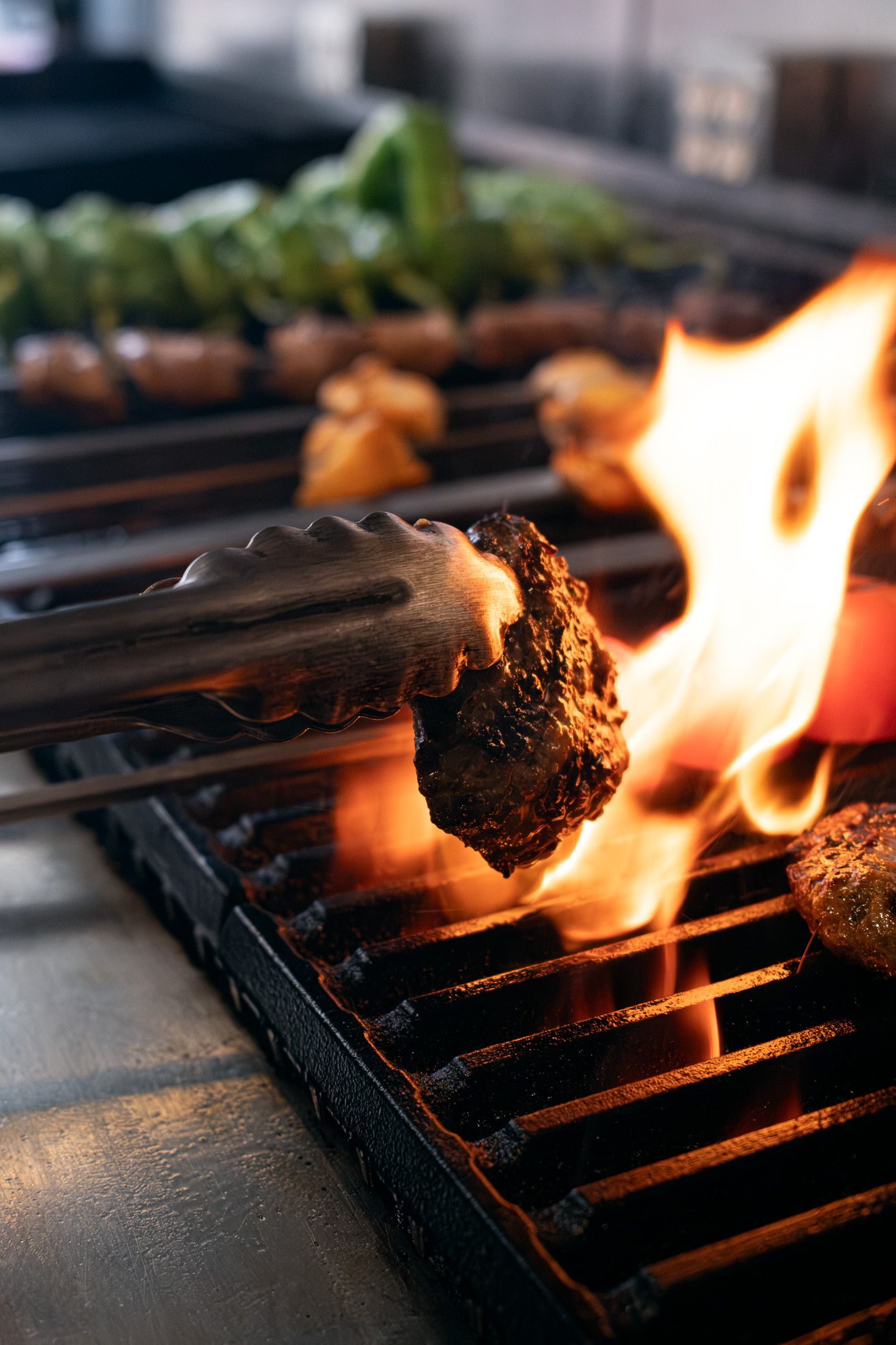 Chef photography of food being grilled over open flames on a black grill grate.