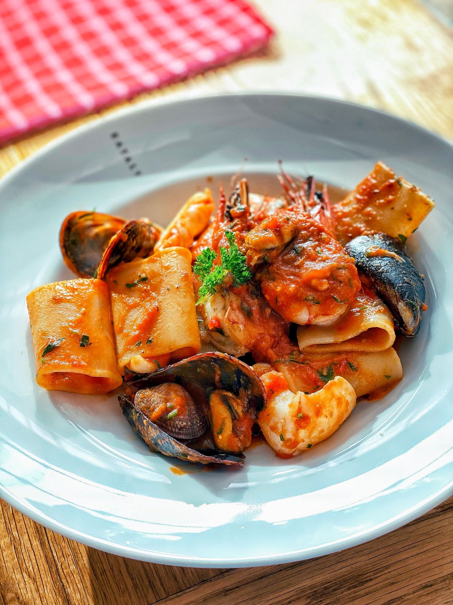 Italian seafood pasta with tomato sauce and shellfish, styled for food photography and social media content.