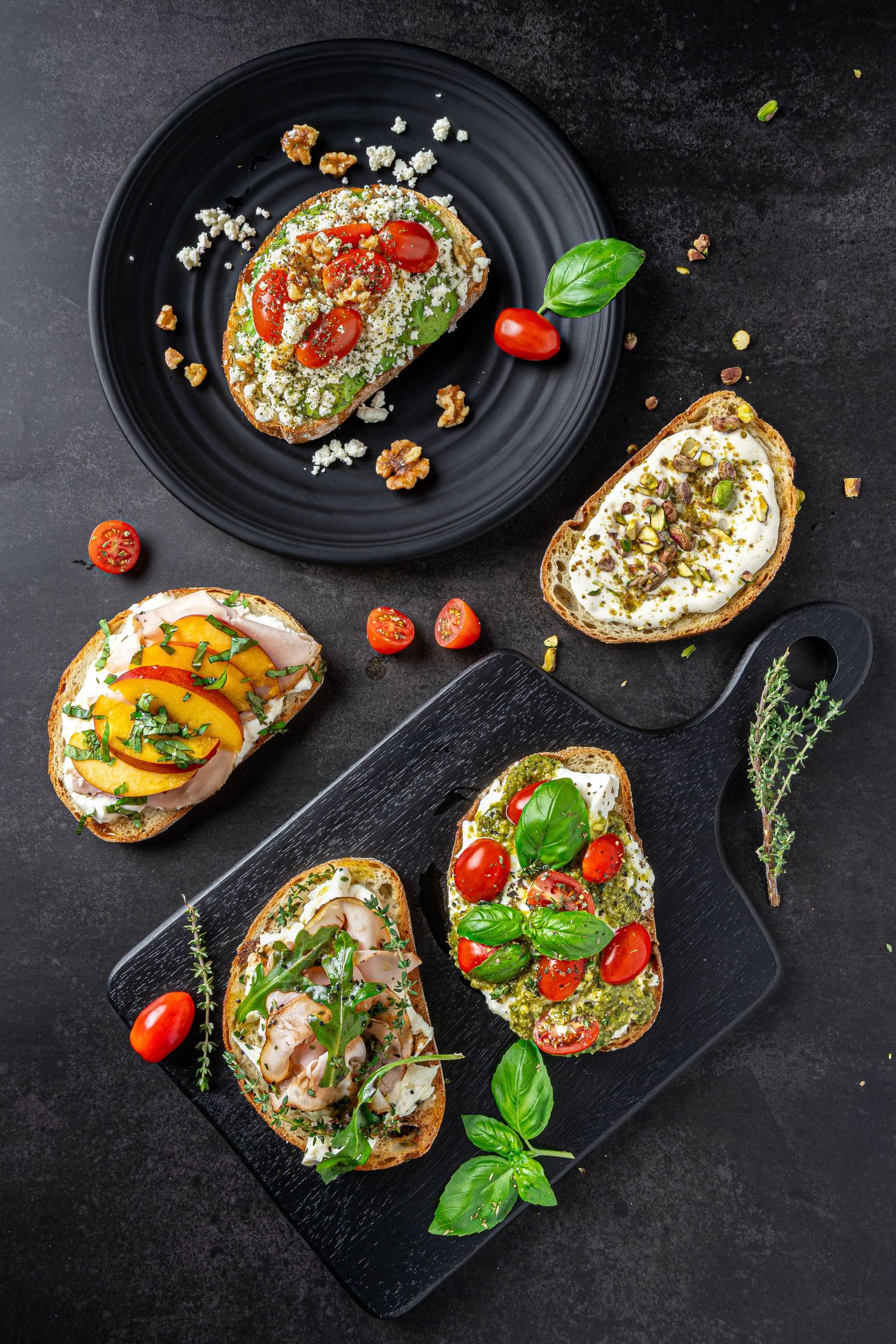 Gourmet bruschetta photography showcasing assorted toppings on black plates, produced for creative visual content.