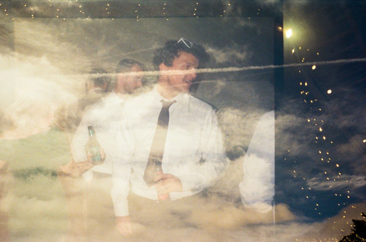 Double exposure artistic wedding photo of a man in white shirt and tie with dreamy clouds.
