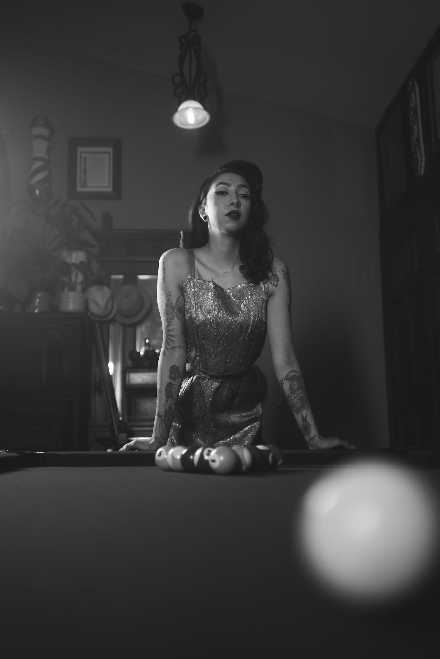 Moody black and white sequence of a person playing billiards in dim lighting.